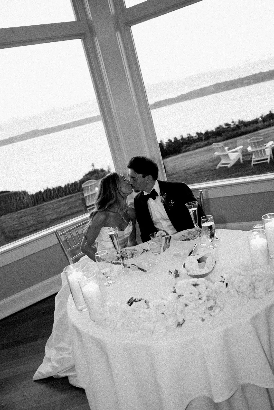 Black-and-white kiss at the sweetheart table, Narragansett Bay window behind