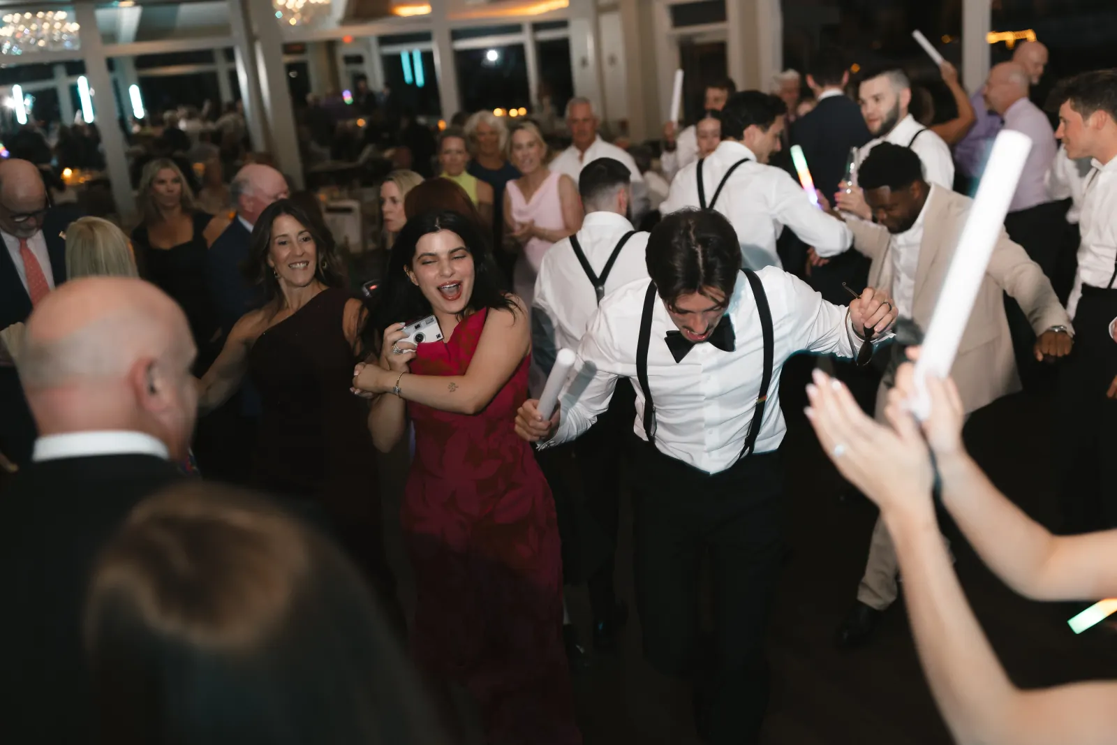 Packed dance floor with glow sticks at the OceanCliff reception