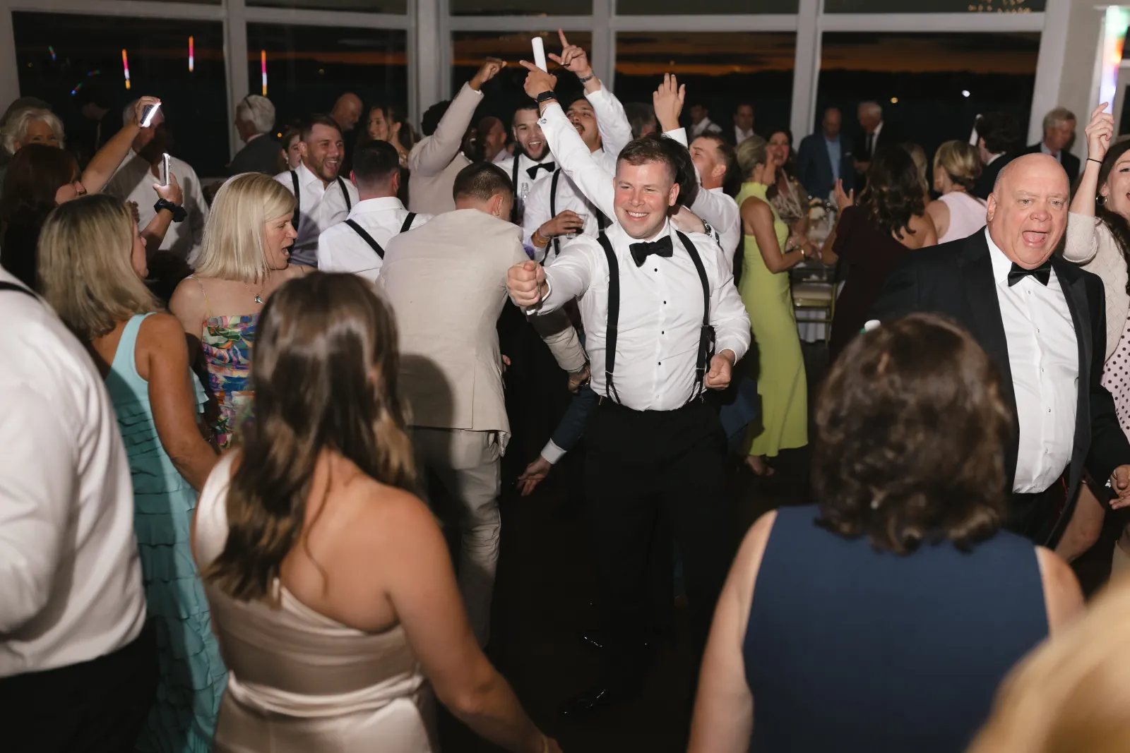 The groom on the dance floor surrounded by guests