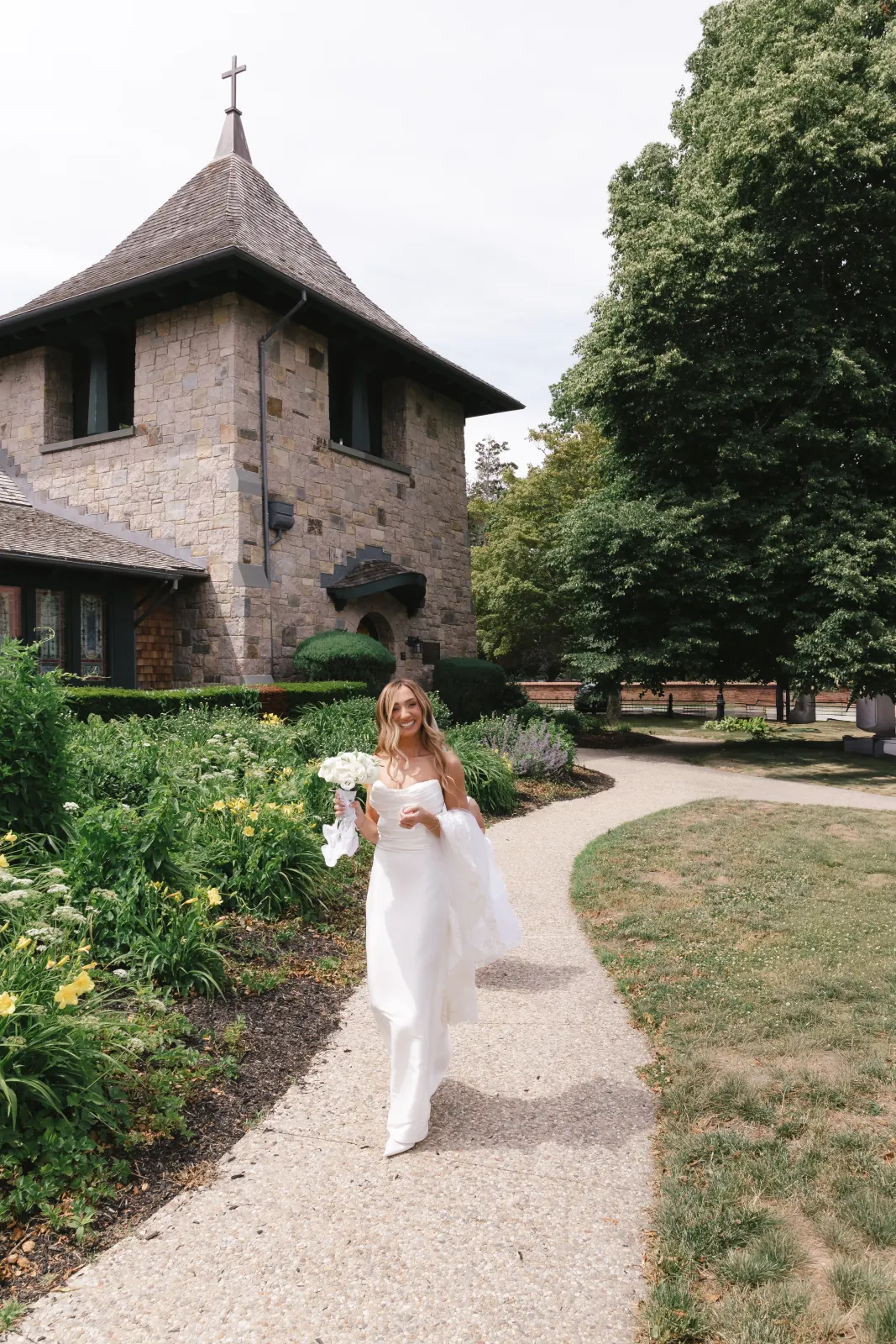 Bride walks the garden path at Our Lady of Mercy Chapel in Newport