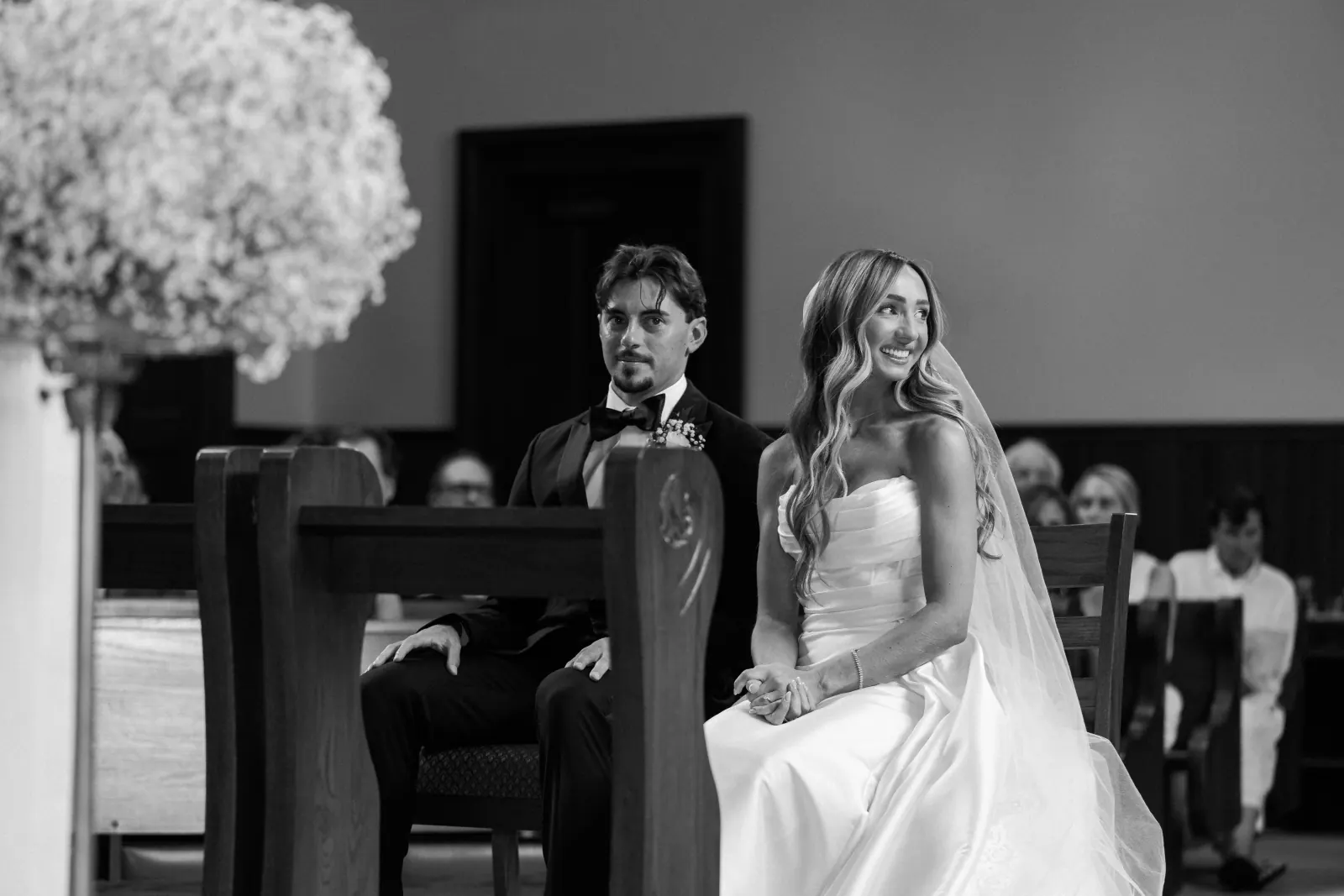 Black-and-white ceremony moment with baby's breath altar florals