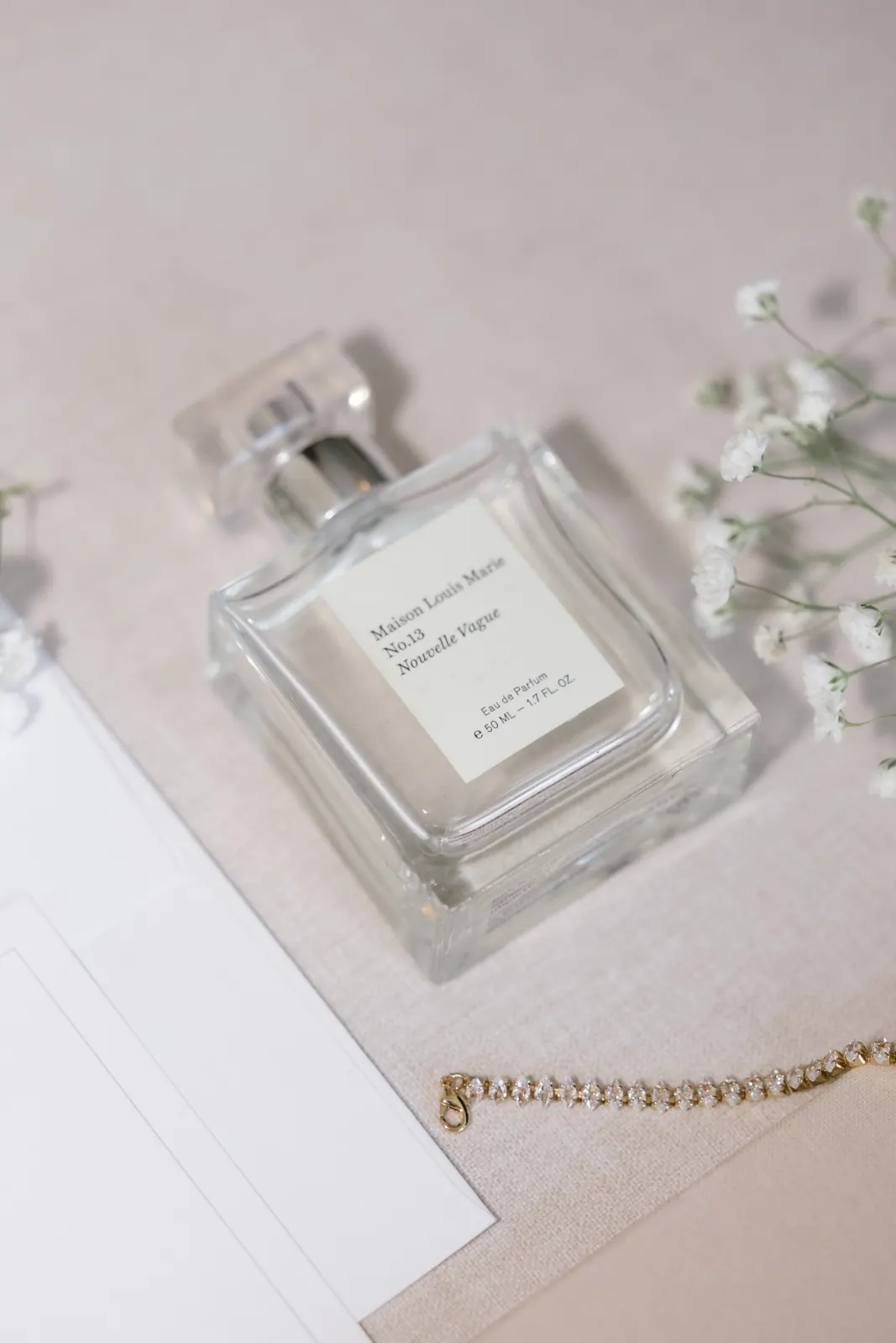 Wedding day details — perfume, a gold bracelet, and baby's breath before a Newport wedding
