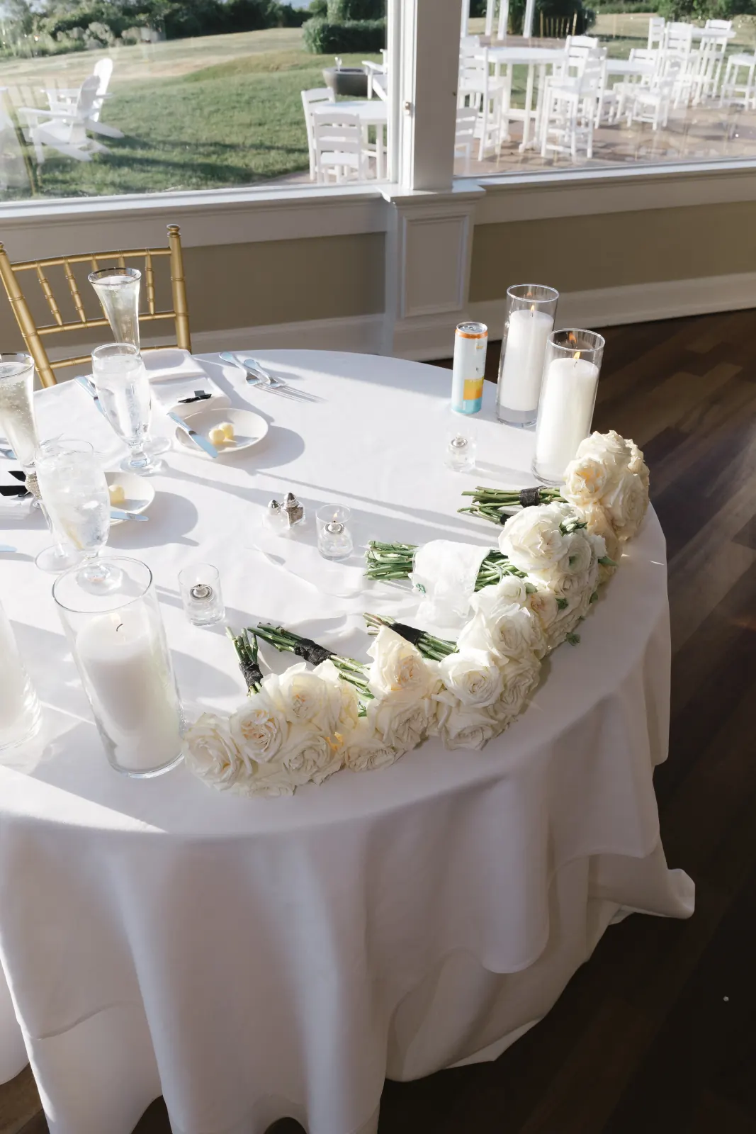 Sweetheart table with a cascading white rose garland and candles, bay view at OceanCliff