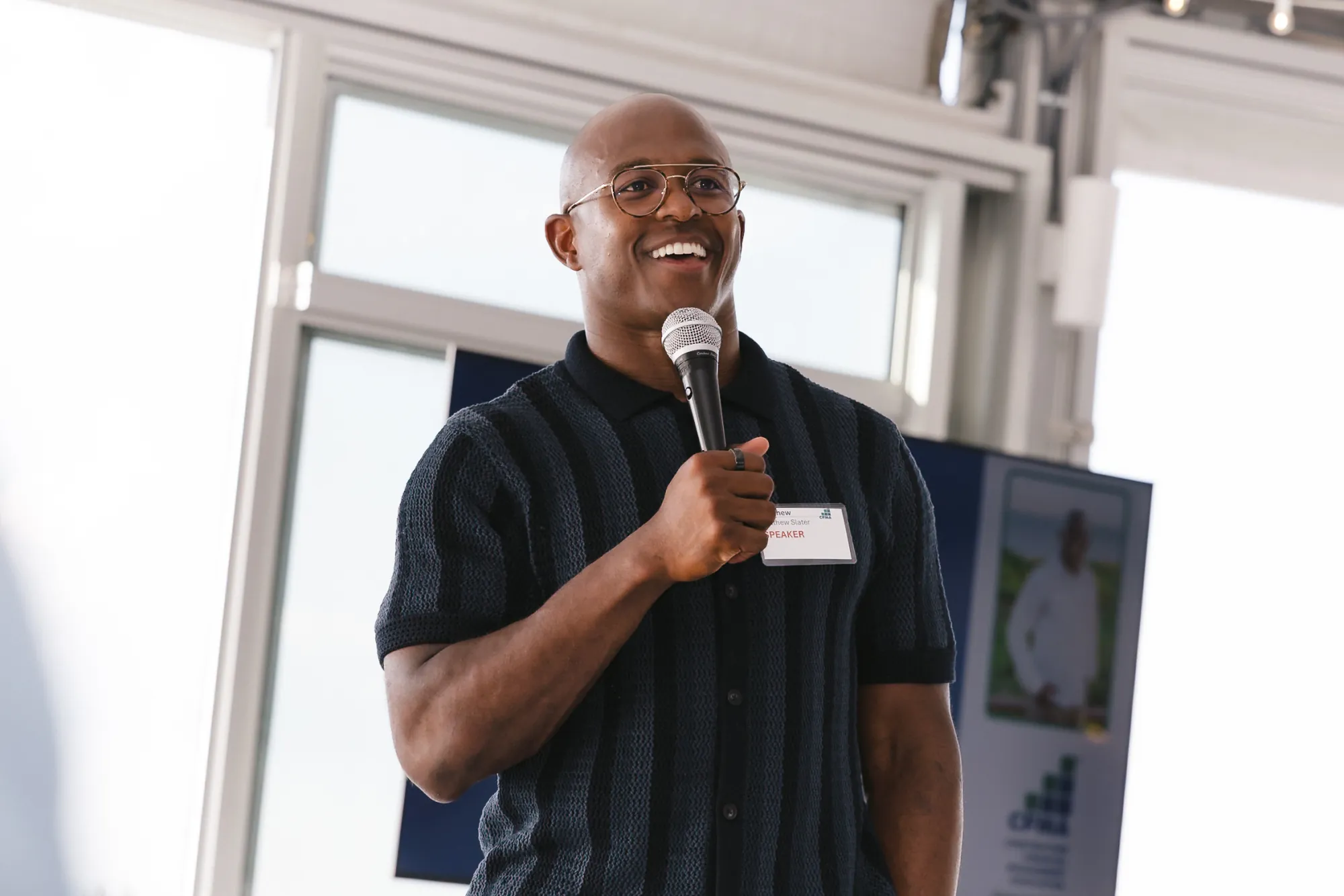 Retired New England Patriots special teams captain Matthew Slater delivering the keynote with a microphone at the 2026 CFMA event at Granite Links Golf Club in Quincy, Massachusetts