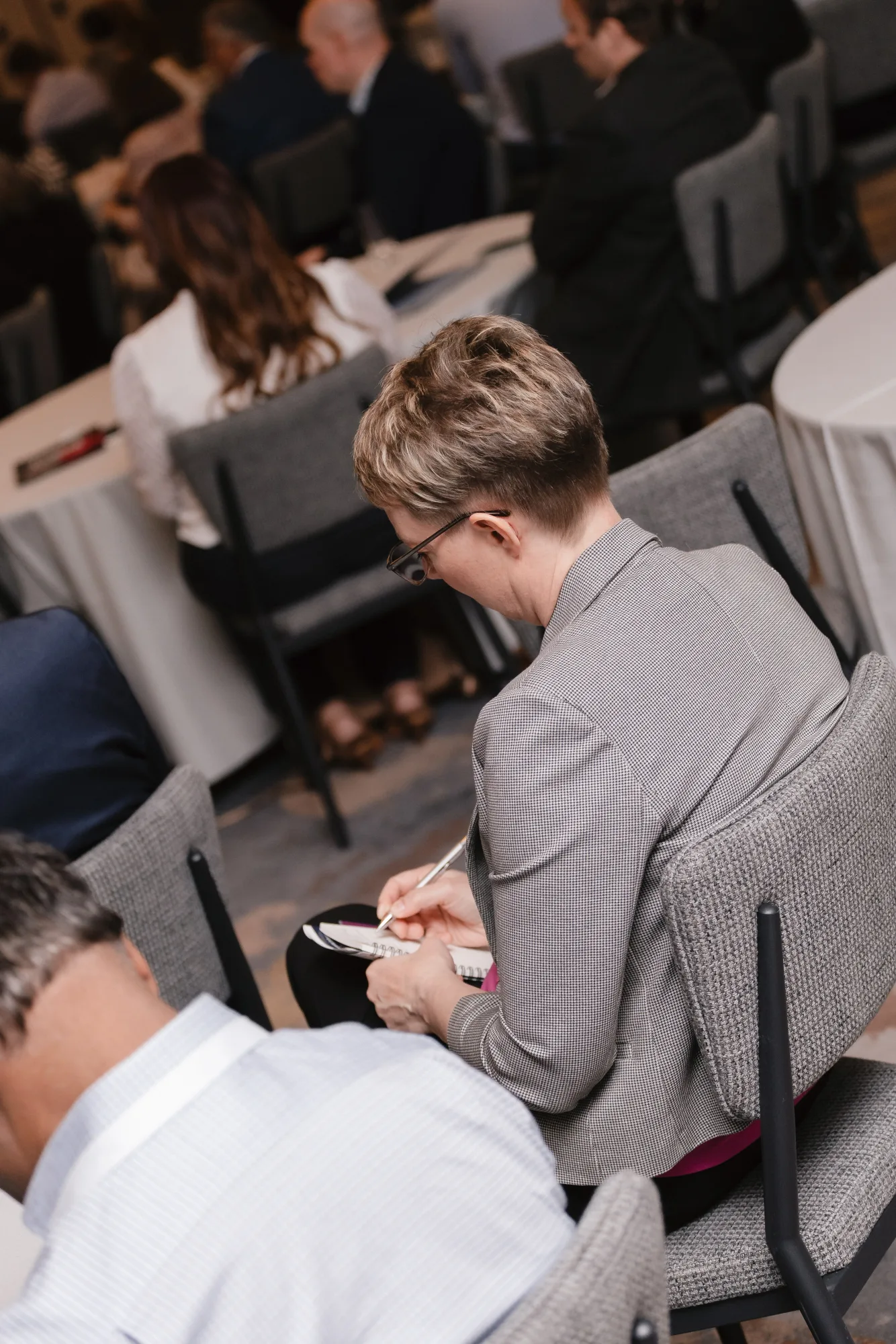 Attendee taking notes during a roundtable at the CFO Leadership Conference, Sheraton Boston