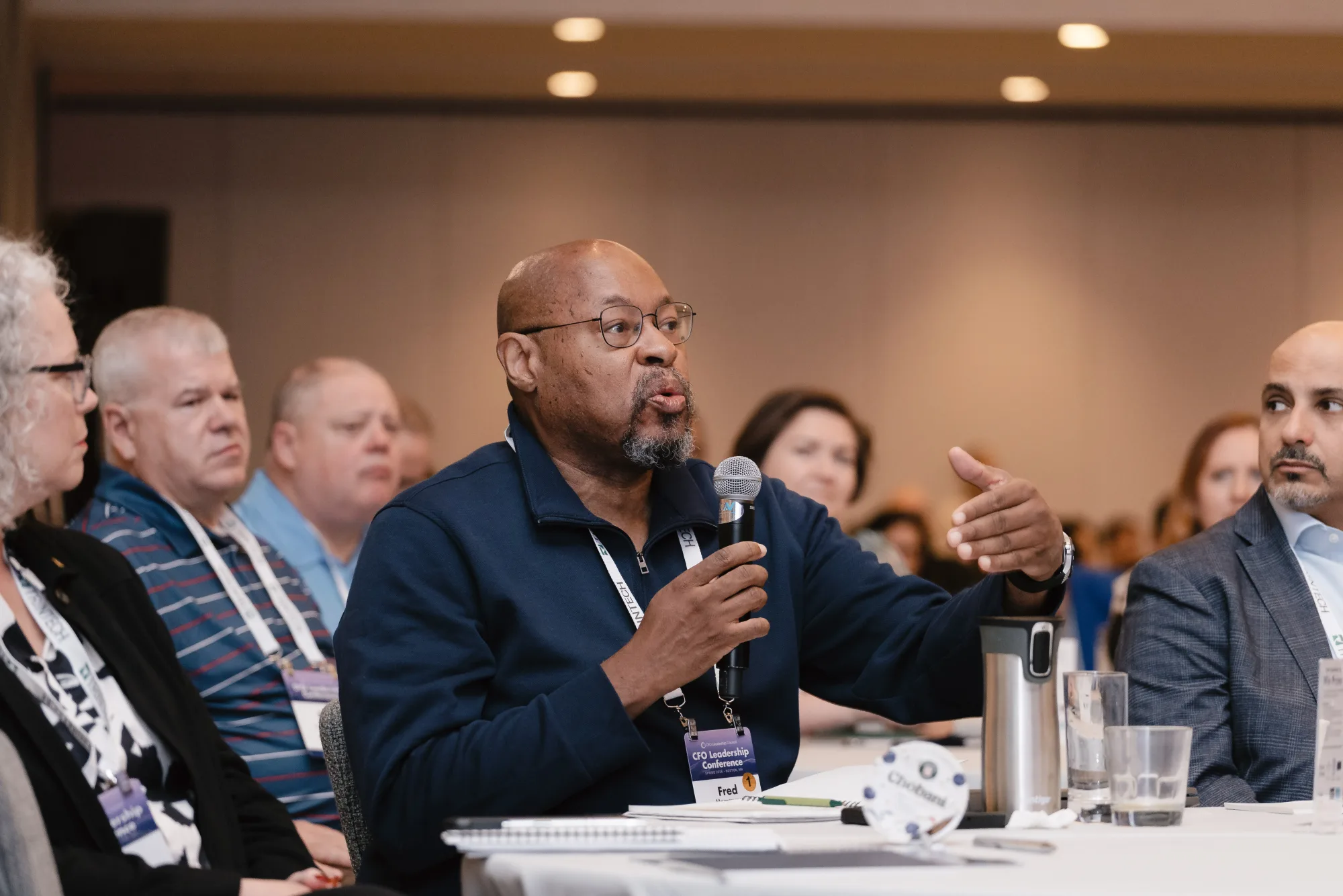 Attendee asking a question with a microphone during a session at the CFO Leadership Conference, Boston
