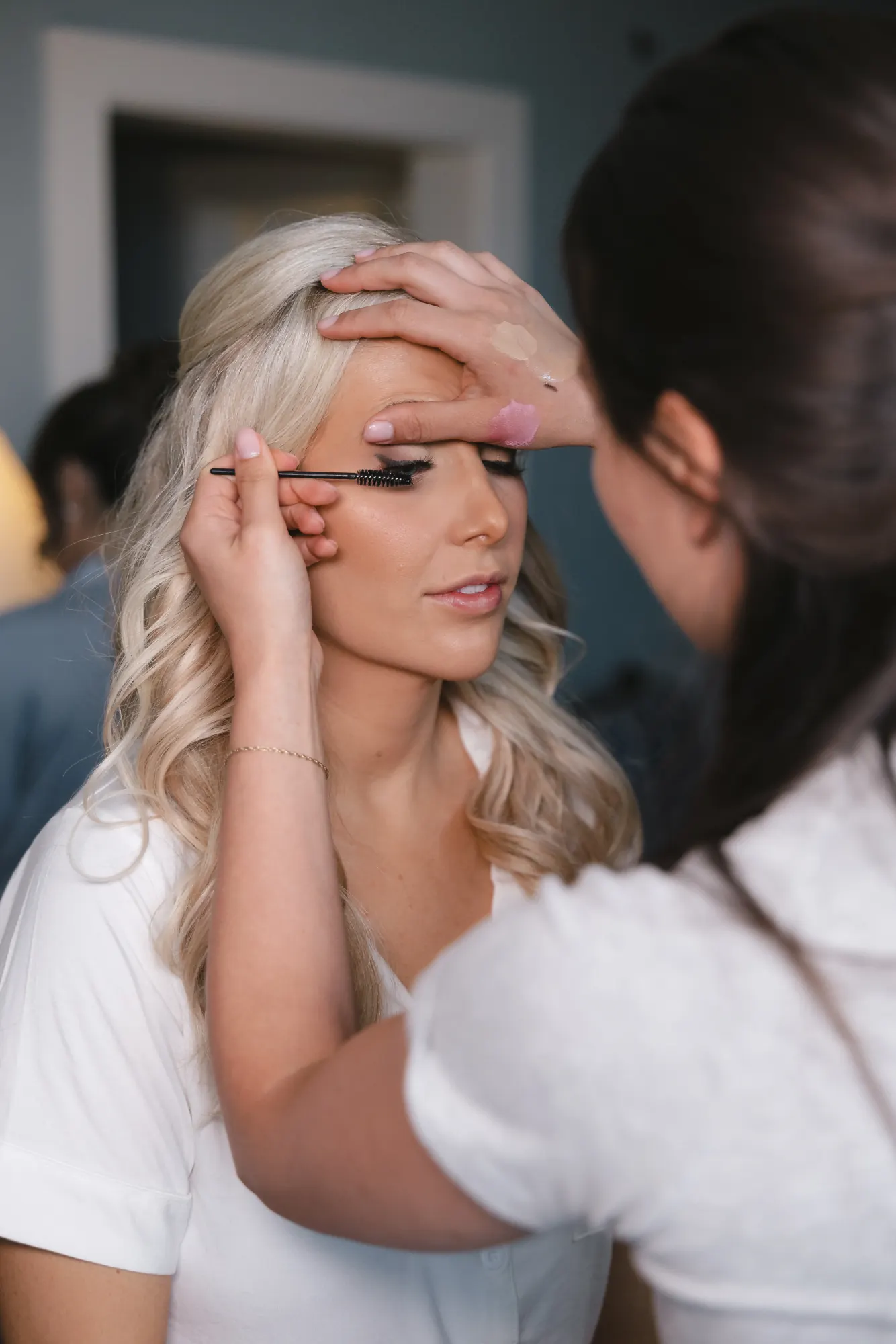 Makeup artist applies the bride's final touches on the wedding morning