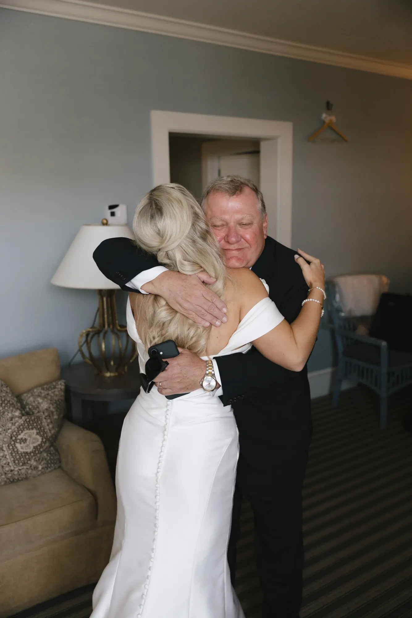 Bride hugs her father before leaving for the church