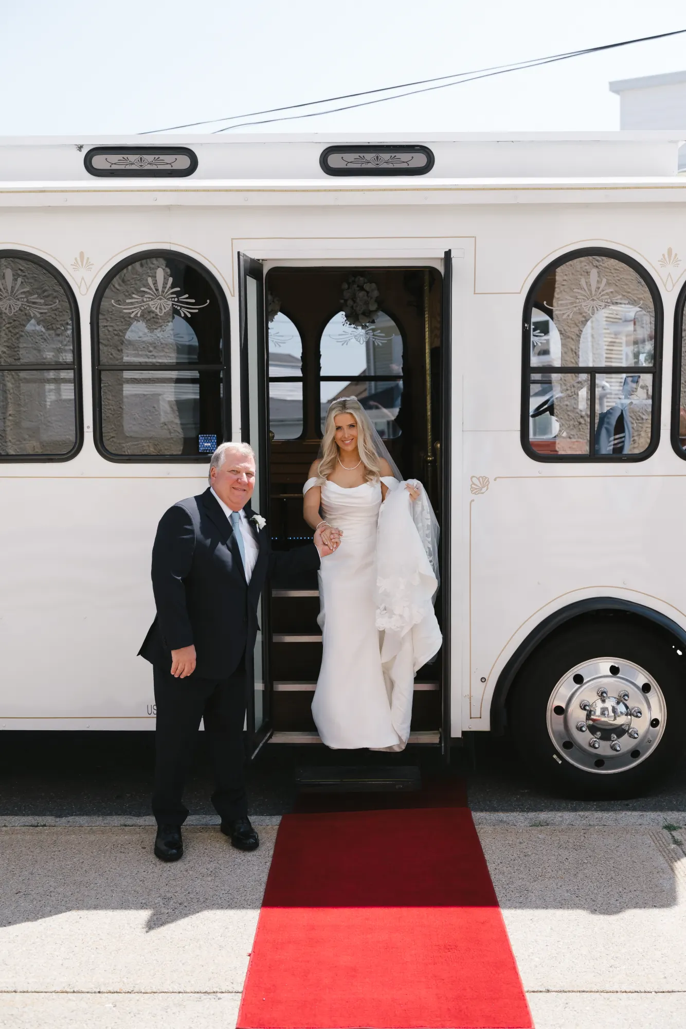 Bride and her father arrive at Our Lady of Good Voyage by white trolley