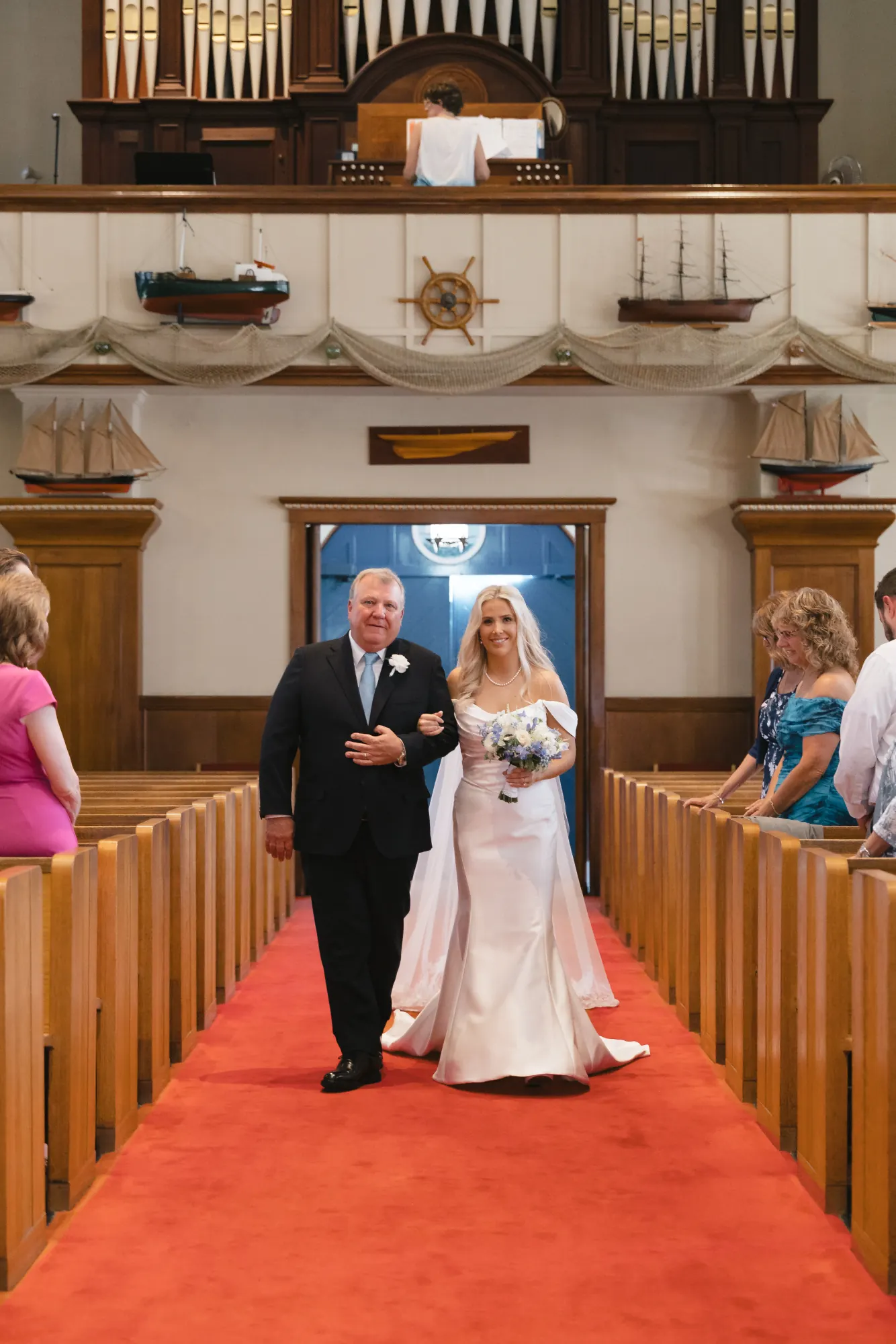 Bride walks the aisle on her father's arm at Our Lady of Good Voyage