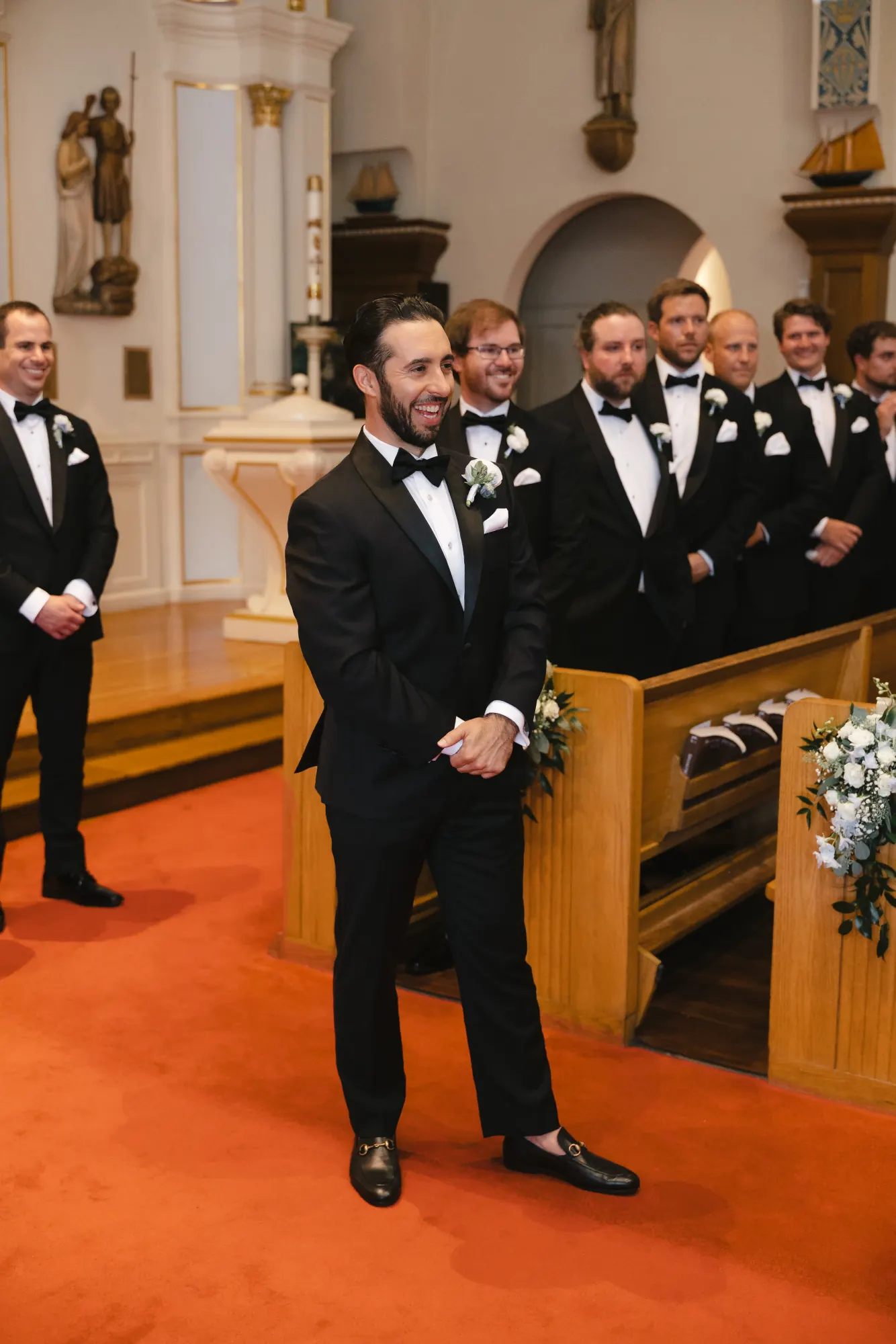 Groom watches the processional from the altar with his groomsmen