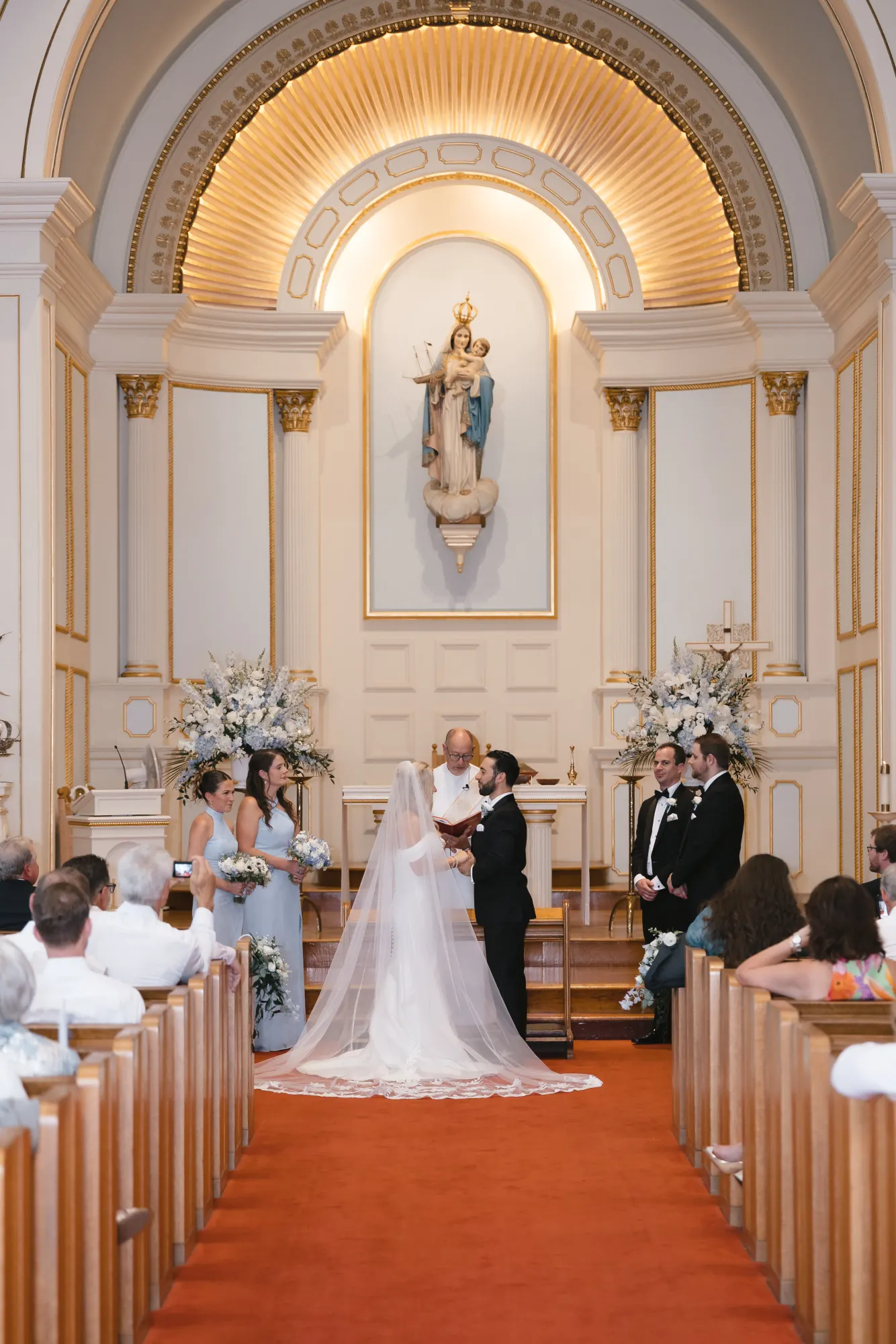 Bride and groom embrace at the altar of the Gloucester fishermen's church