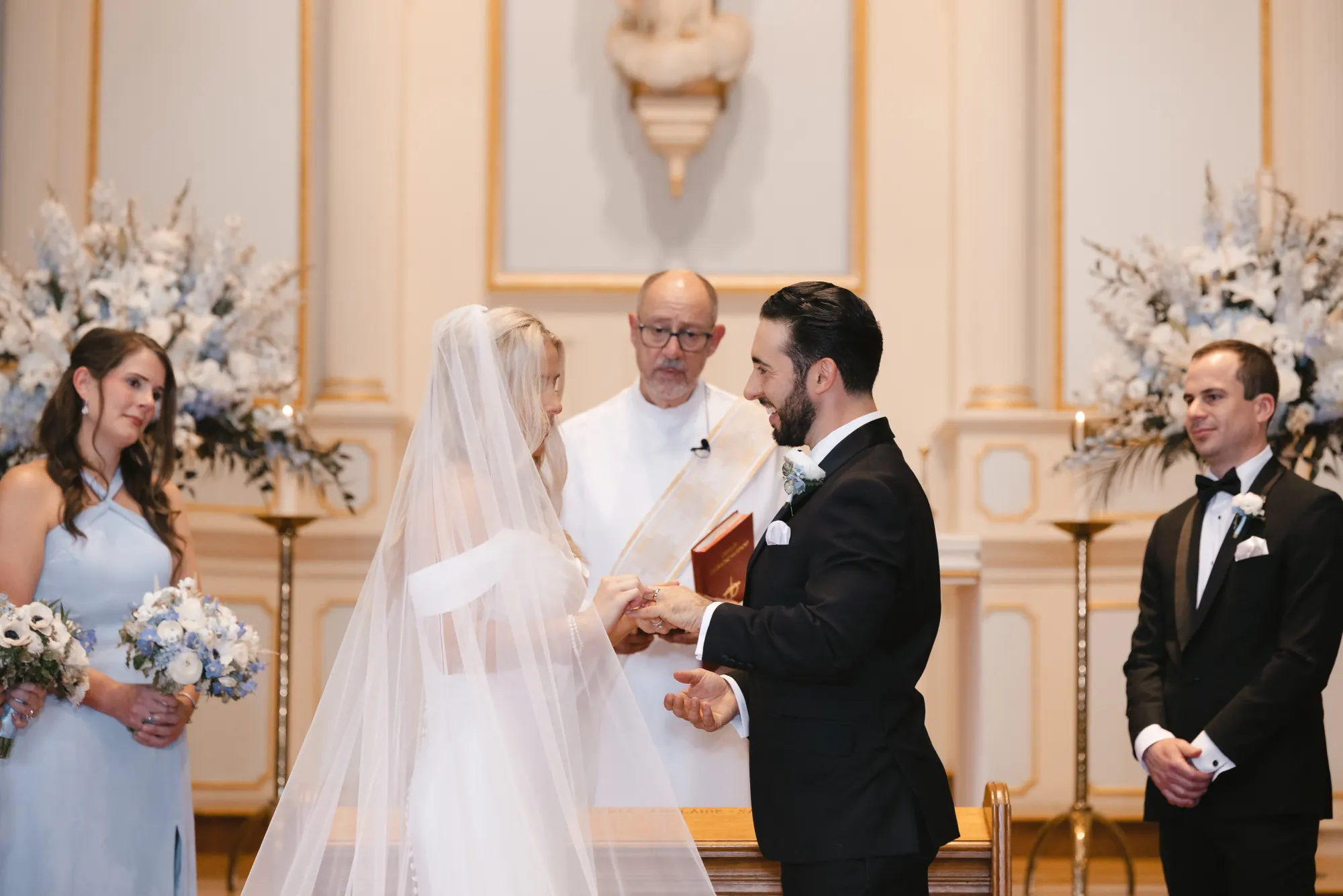 Chris and Abby exchange vows before the priest at Our Lady of Good Voyage