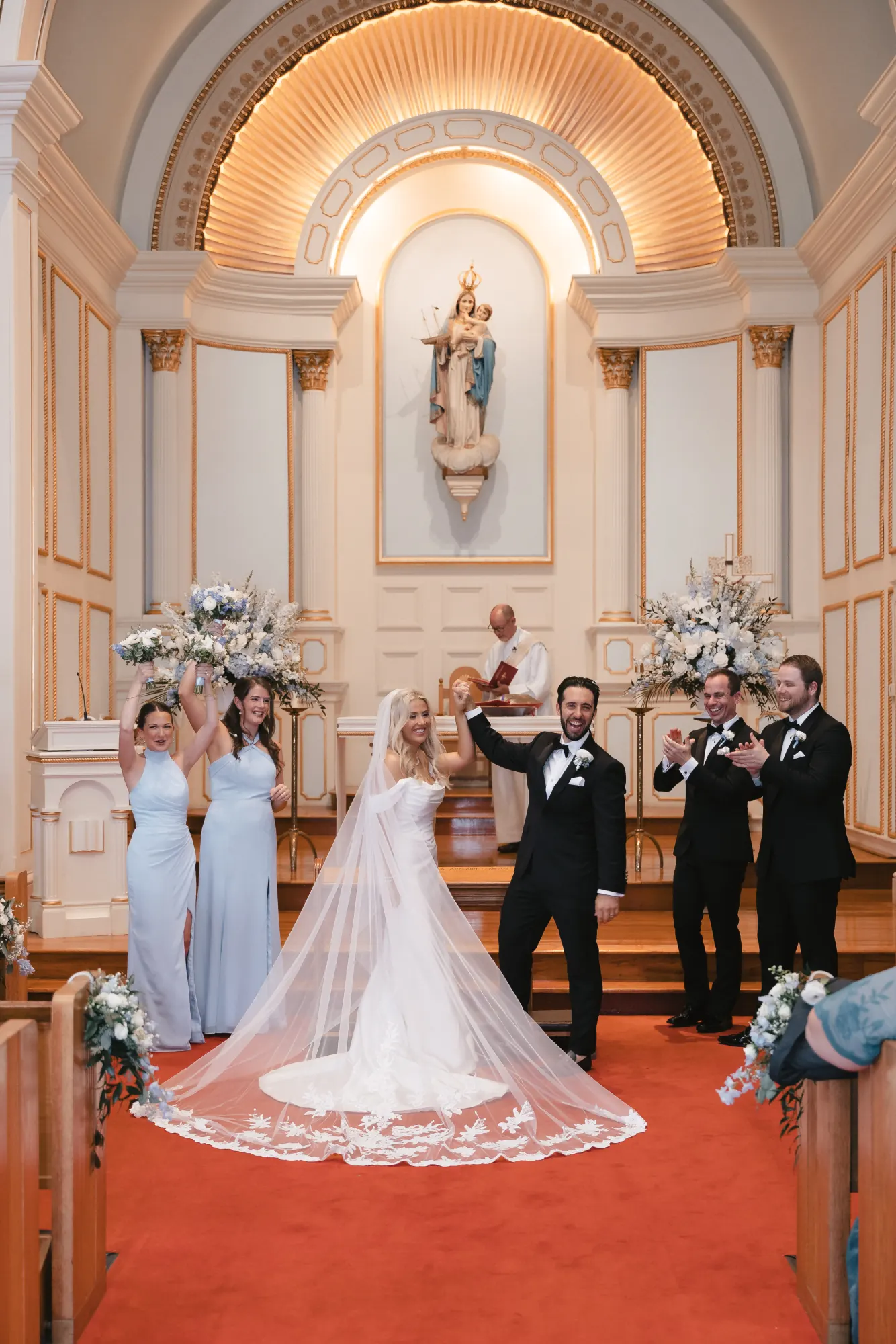 The wedding party celebrates at the altar after the first kiss