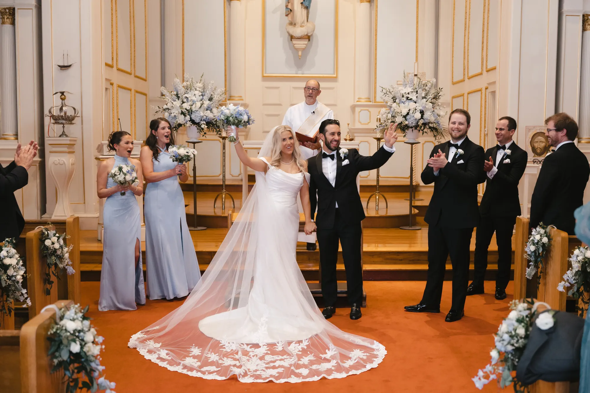 Groom raises his arms in celebration at the altar