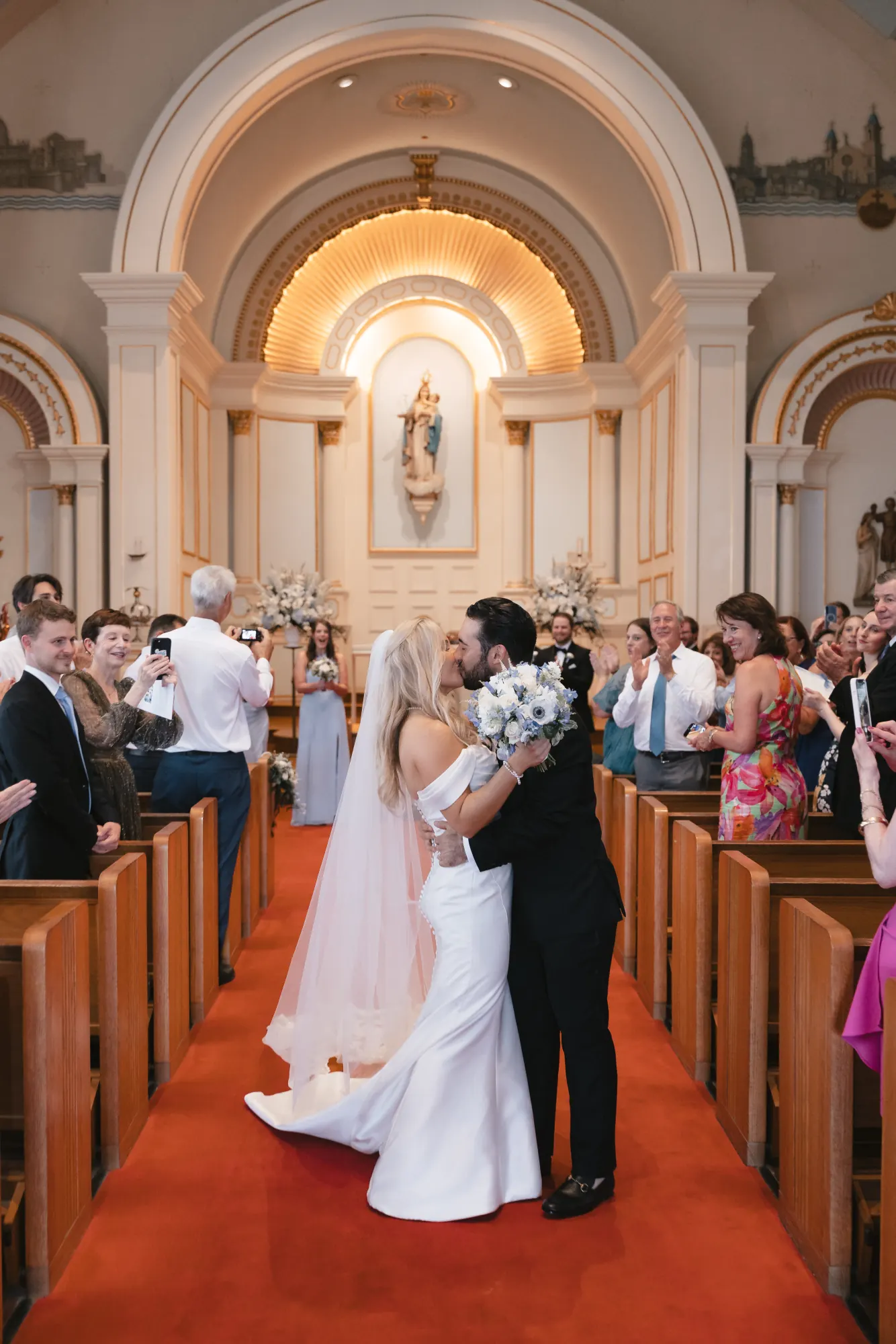 Bride and groom embrace mid-aisle during the recessional