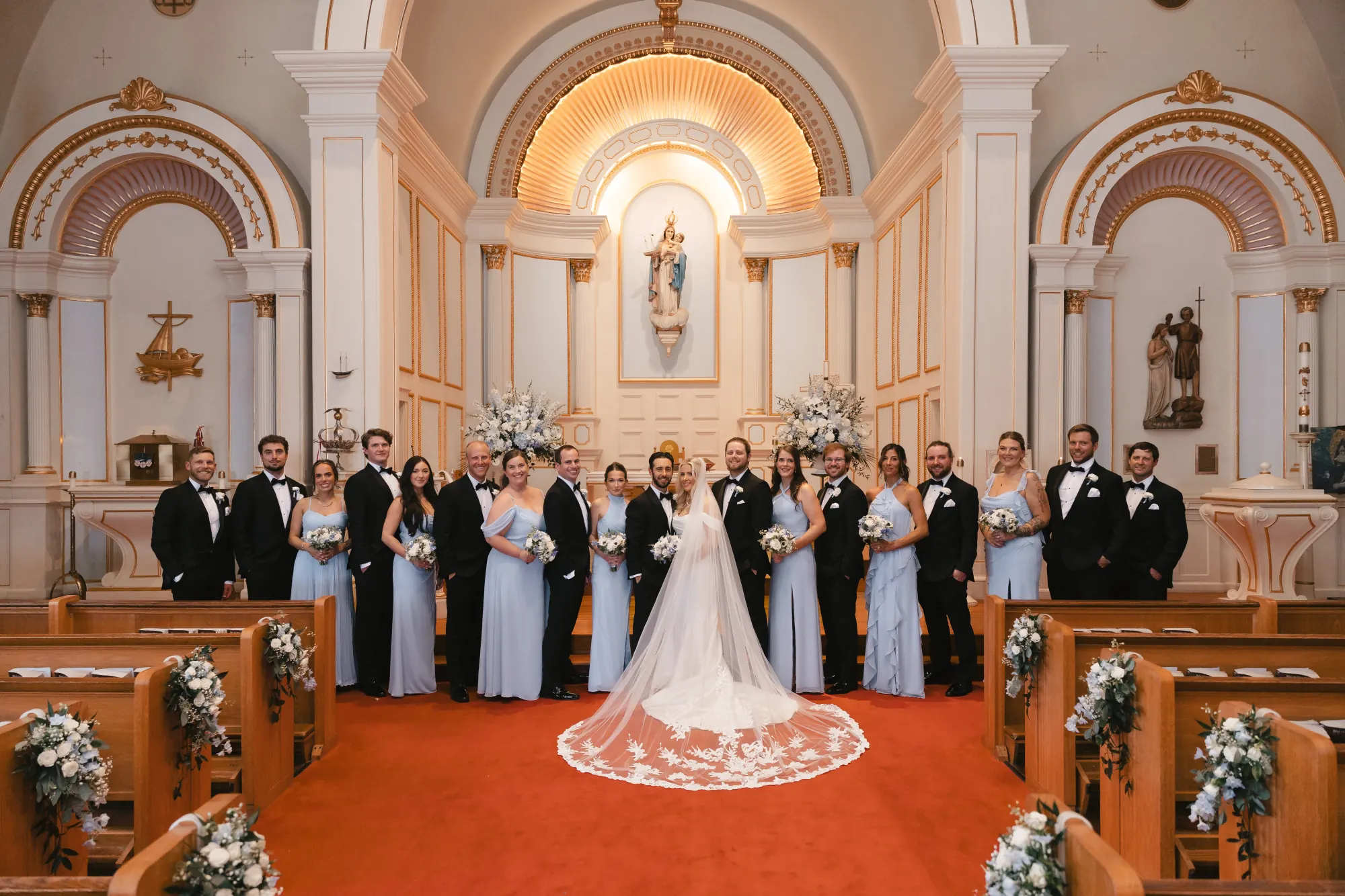The full wedding party at the altar of Our Lady of Good Voyage in Gloucester