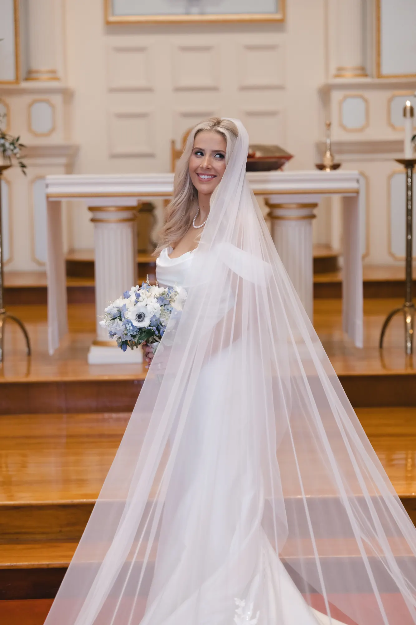 Bride portrait at the altar with her bouquet of white and blue blooms