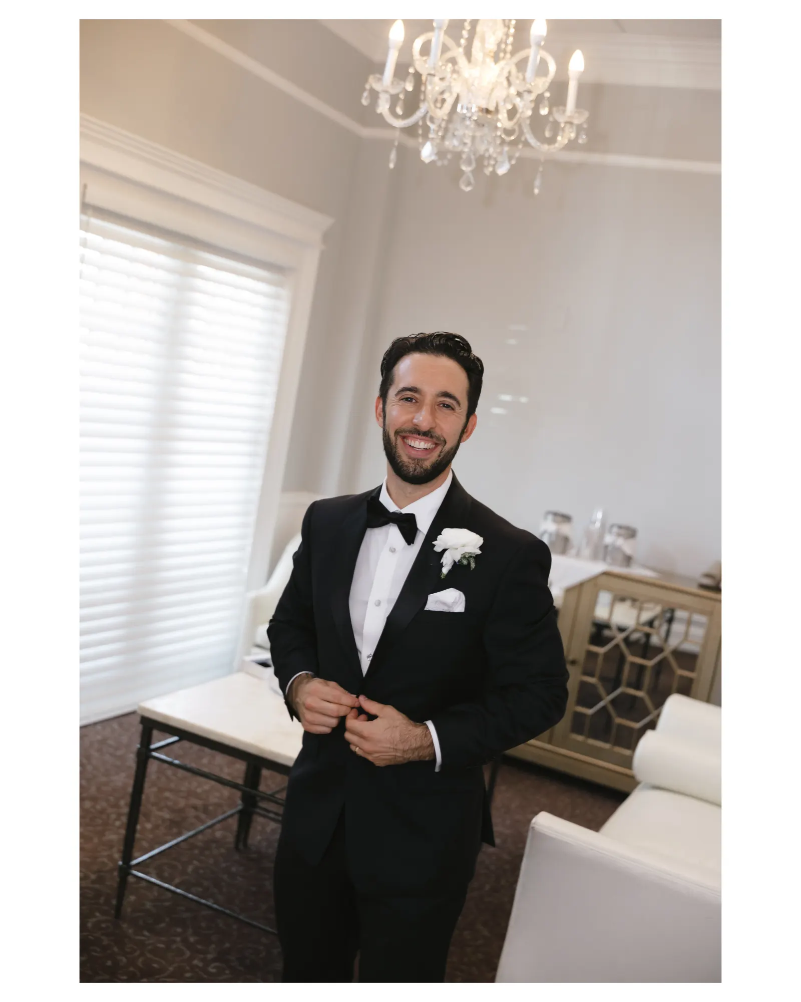 Groom buttons his tuxedo jacket at Cruiseport Gloucester