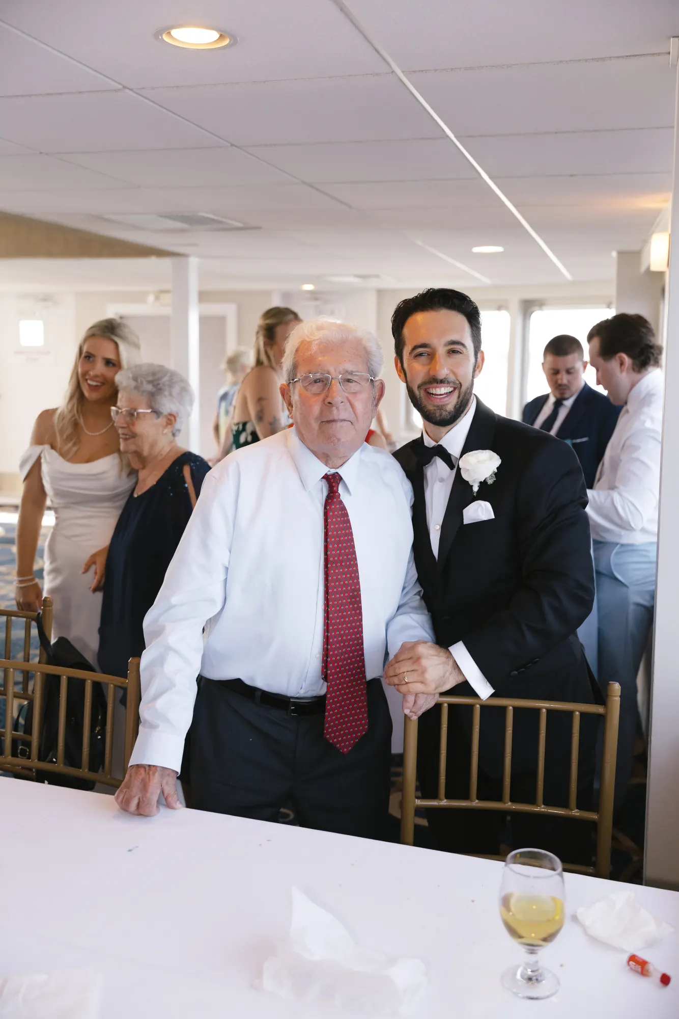 Groom shares a moment with family at the table aboard the cruise
