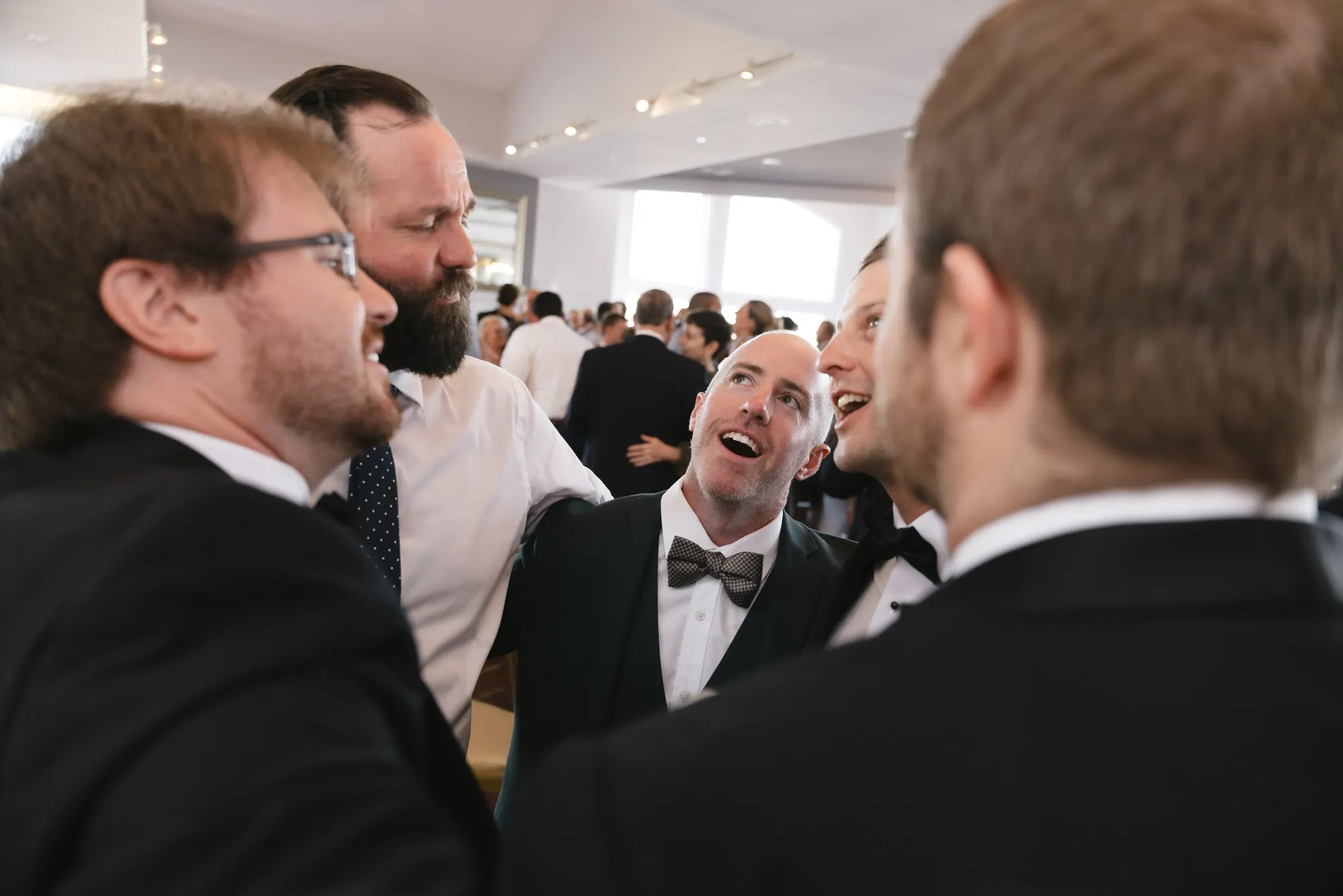 Groomsmen share a laugh during the reception