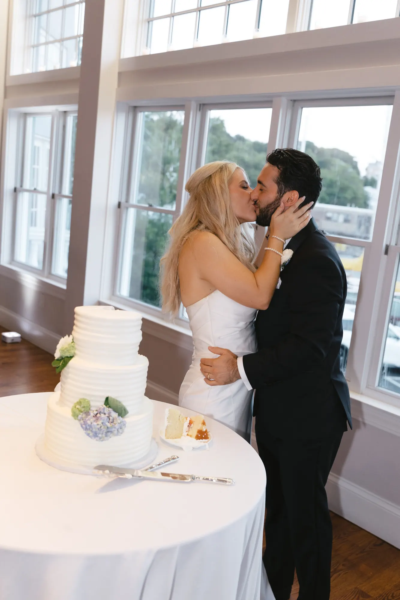 Newlyweds kiss behind their wedding cake at Cruiseport Gloucester