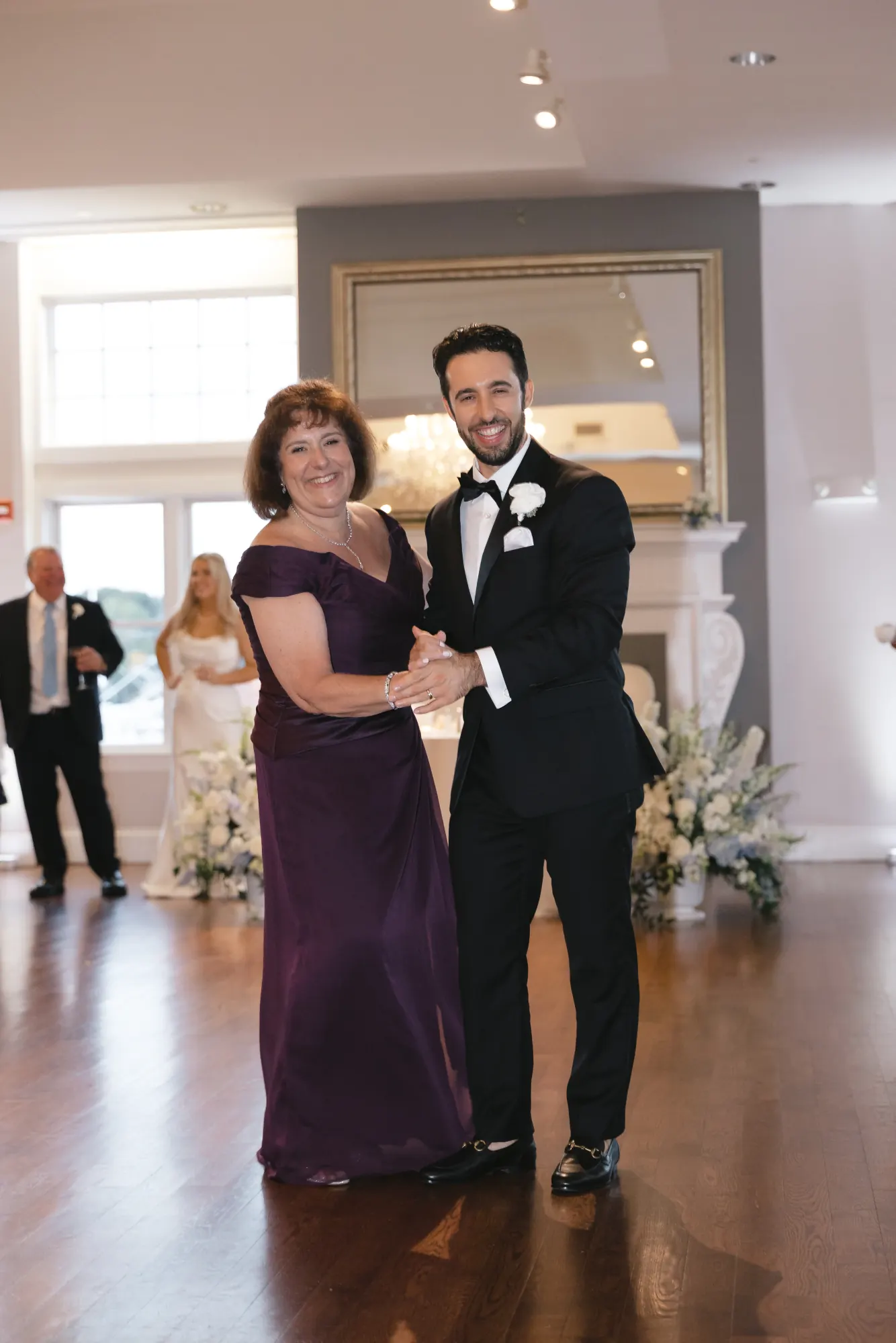 Groom and his mother smile during the mother-son dance