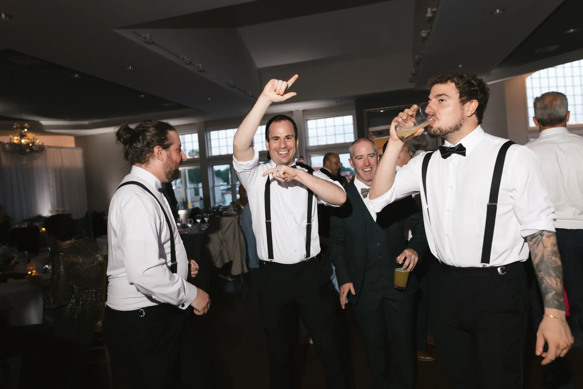 Groomsmen in suspenders dance late into the night