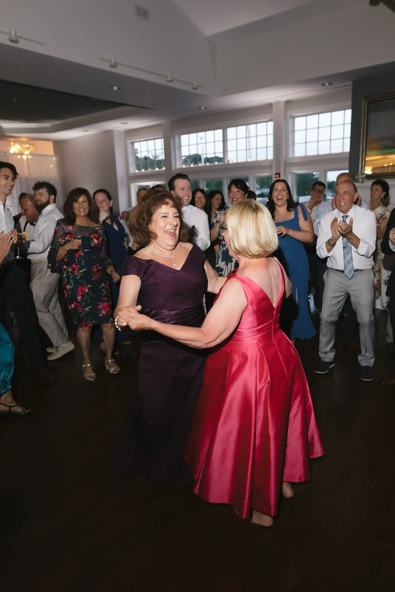 The mothers of the couple dance together at the reception