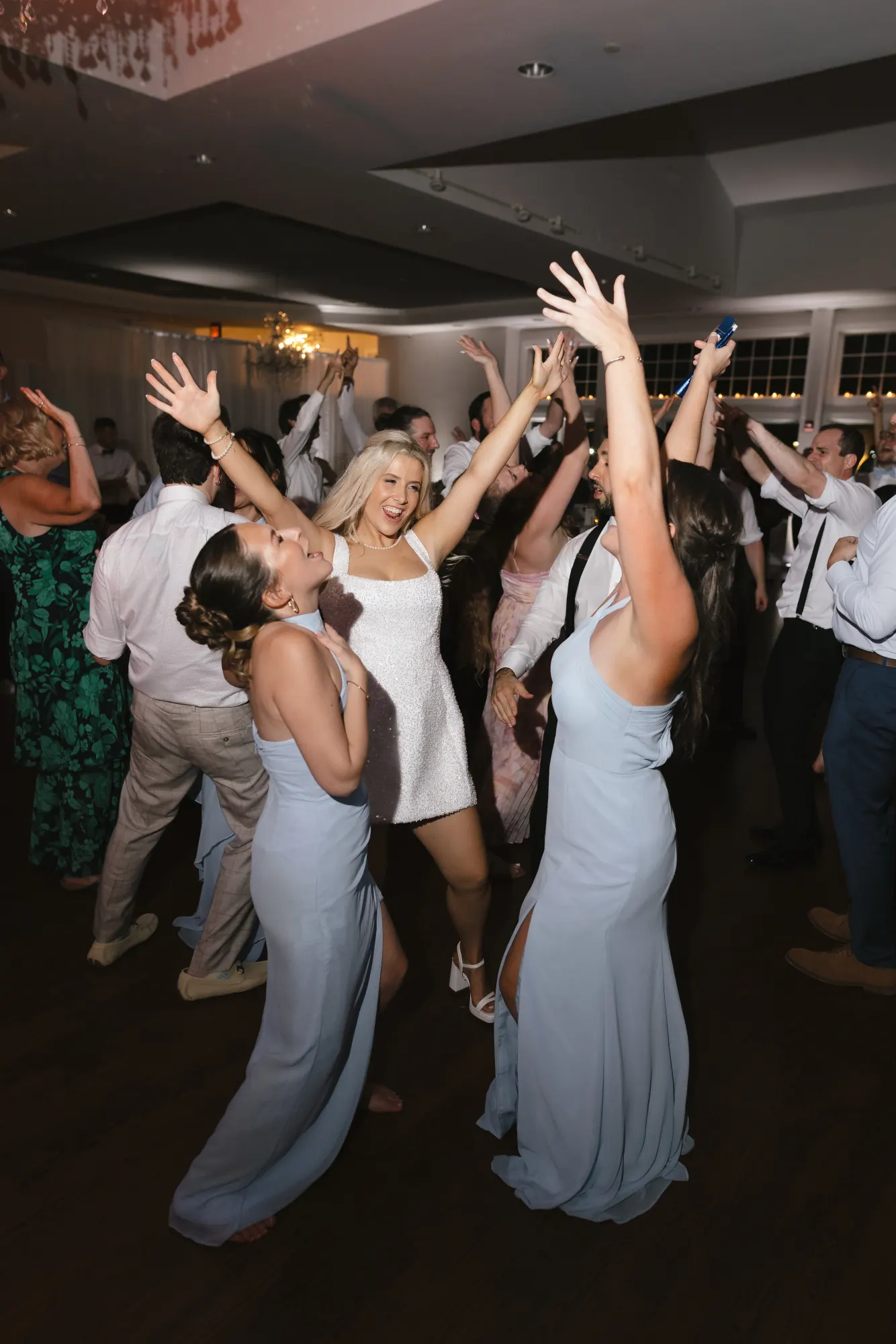 Bride and bridesmaids dance with hands raised to close out the night