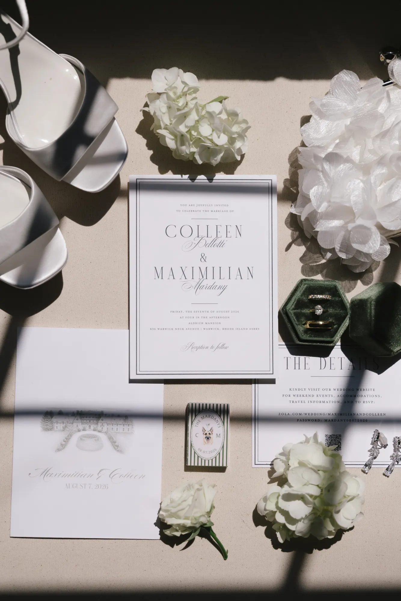Invitation suite flat lay with the bride's heels, a green velvet ring box, and white hydrangea