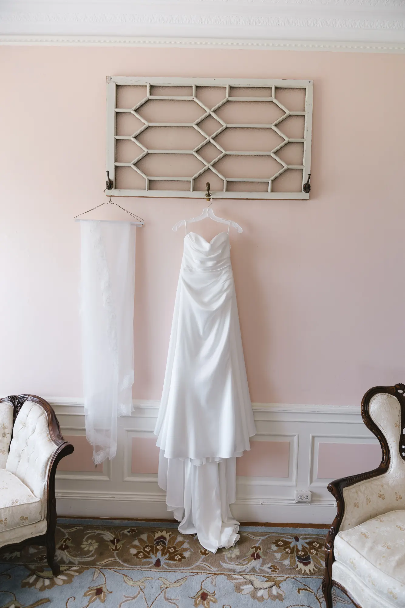 The gown and veil hang in the pink bridal suite at Aldrich Mansion