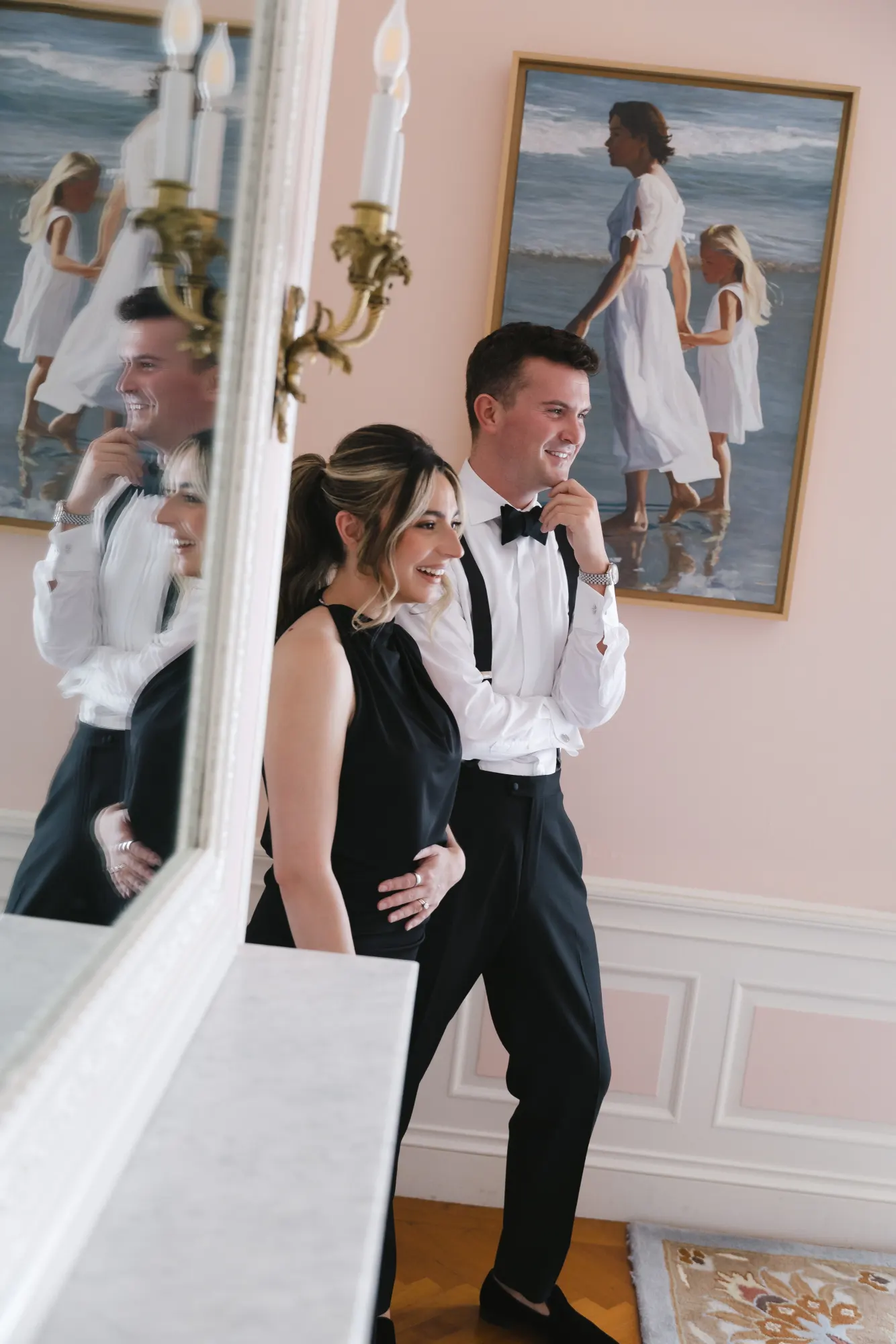 The groom gets ready in front of the mirror before the first look