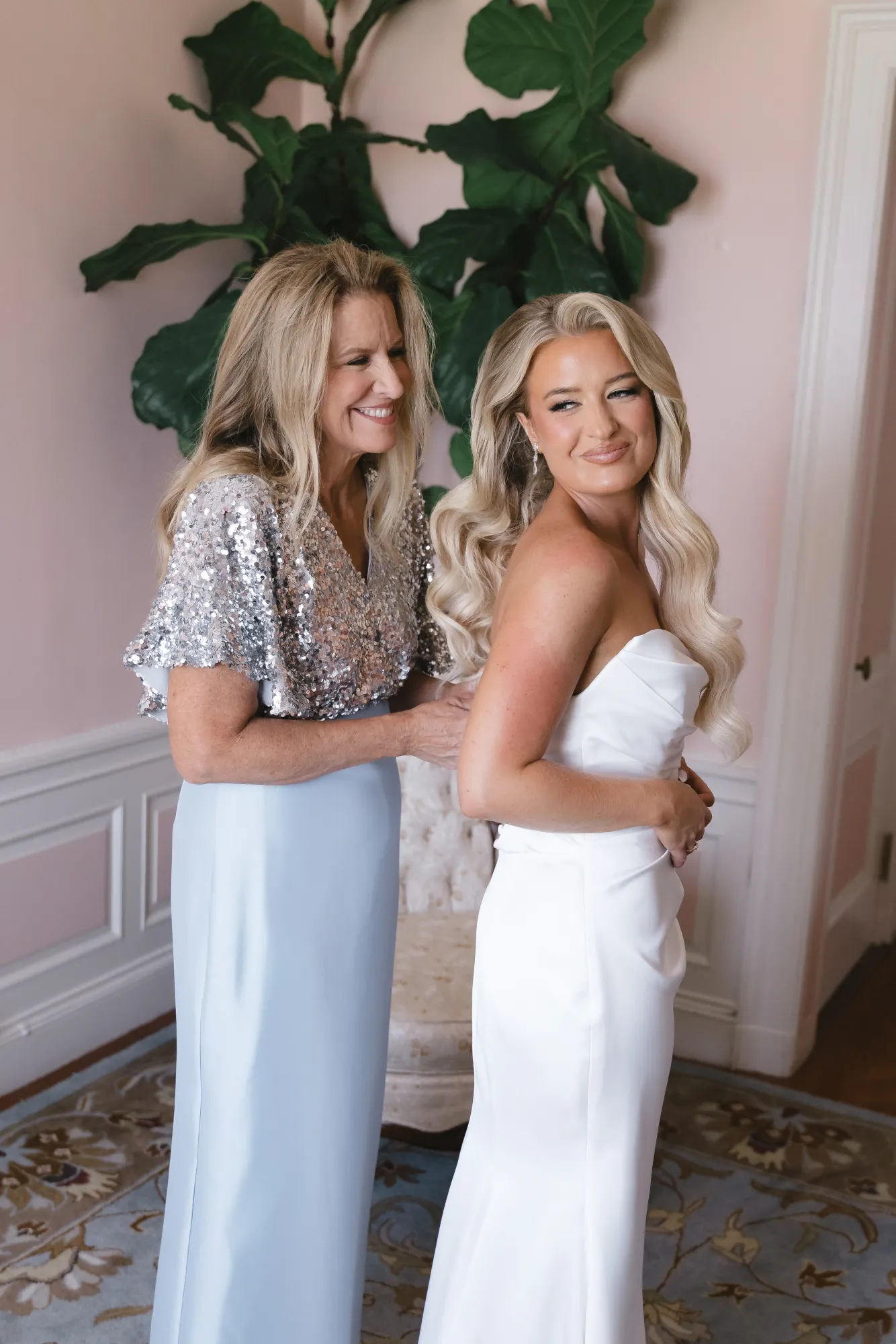 The bride and her mom share a smile while getting ready