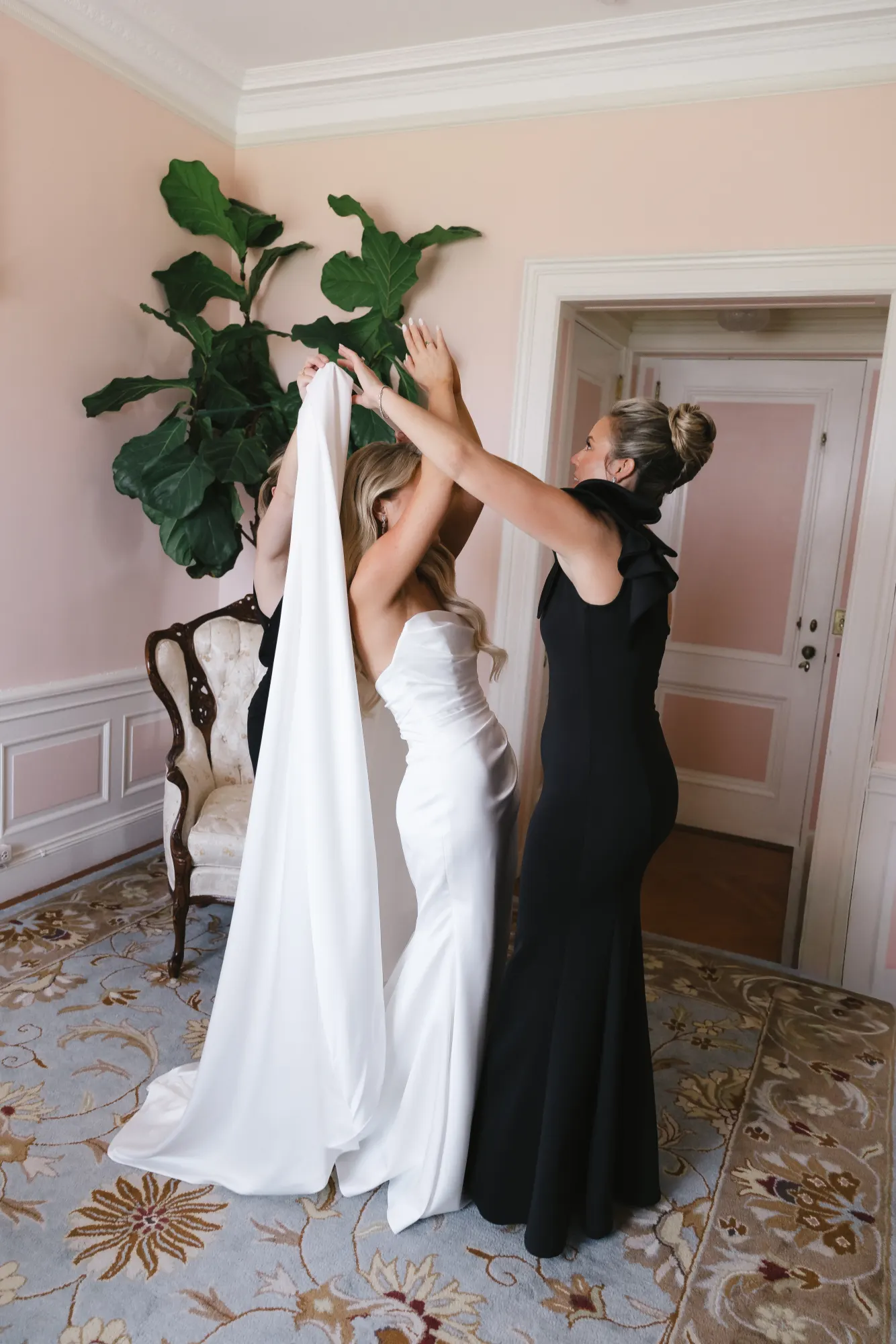 The veil is lifted into place in the bridal suite