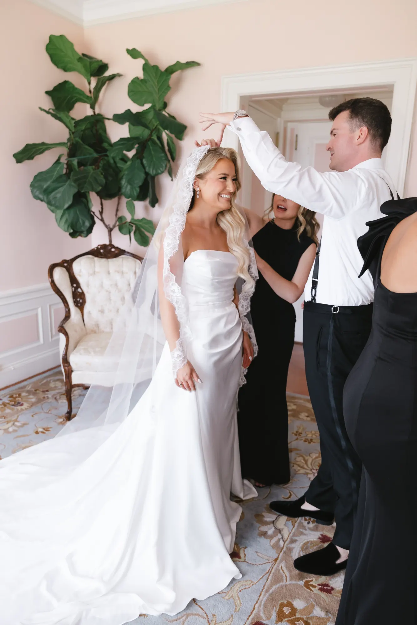 The veil goes on over her curls in the bridal suite