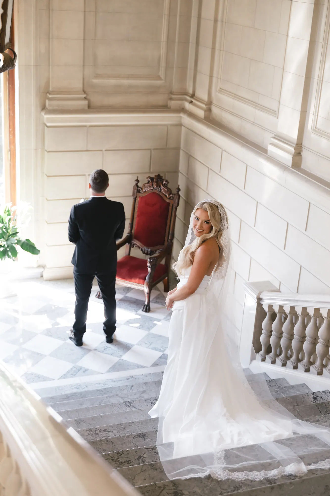 Colleen reaches for Max's shoulder on the mansion staircase