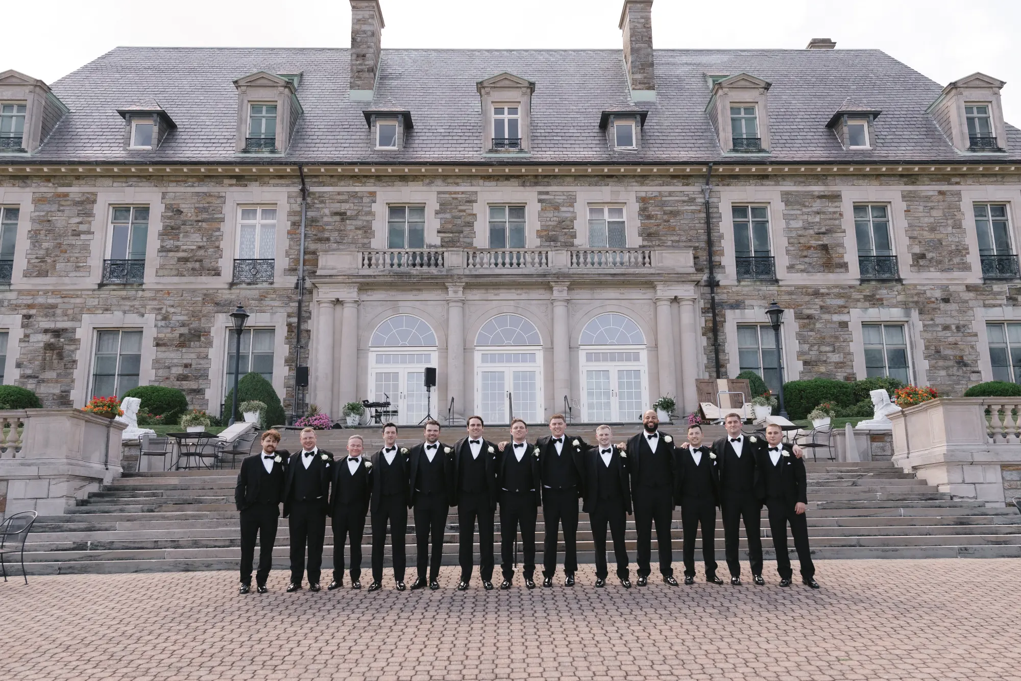 The groomsmen lined up across the terrace courtyard