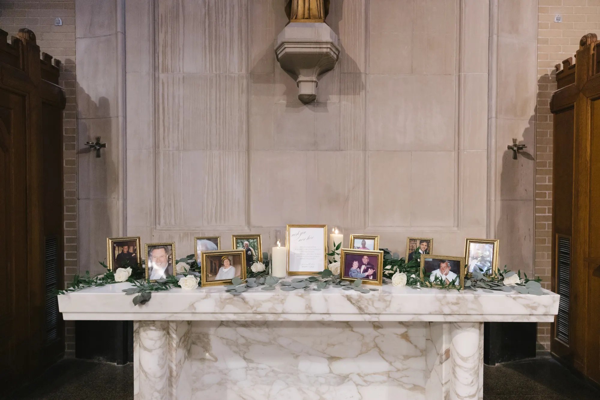 A display of family wedding photographs and a memorial candle in the chapel