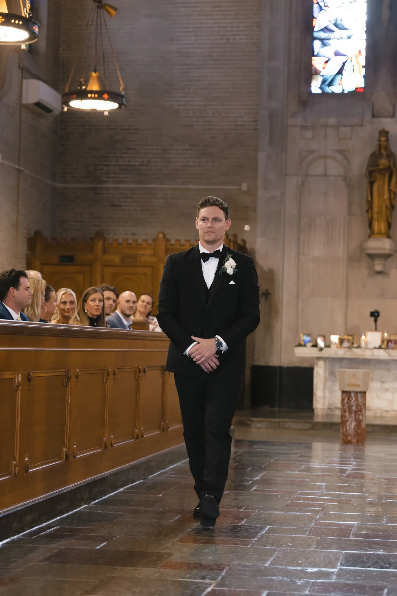 Max waits at the front of the chapel for the processional