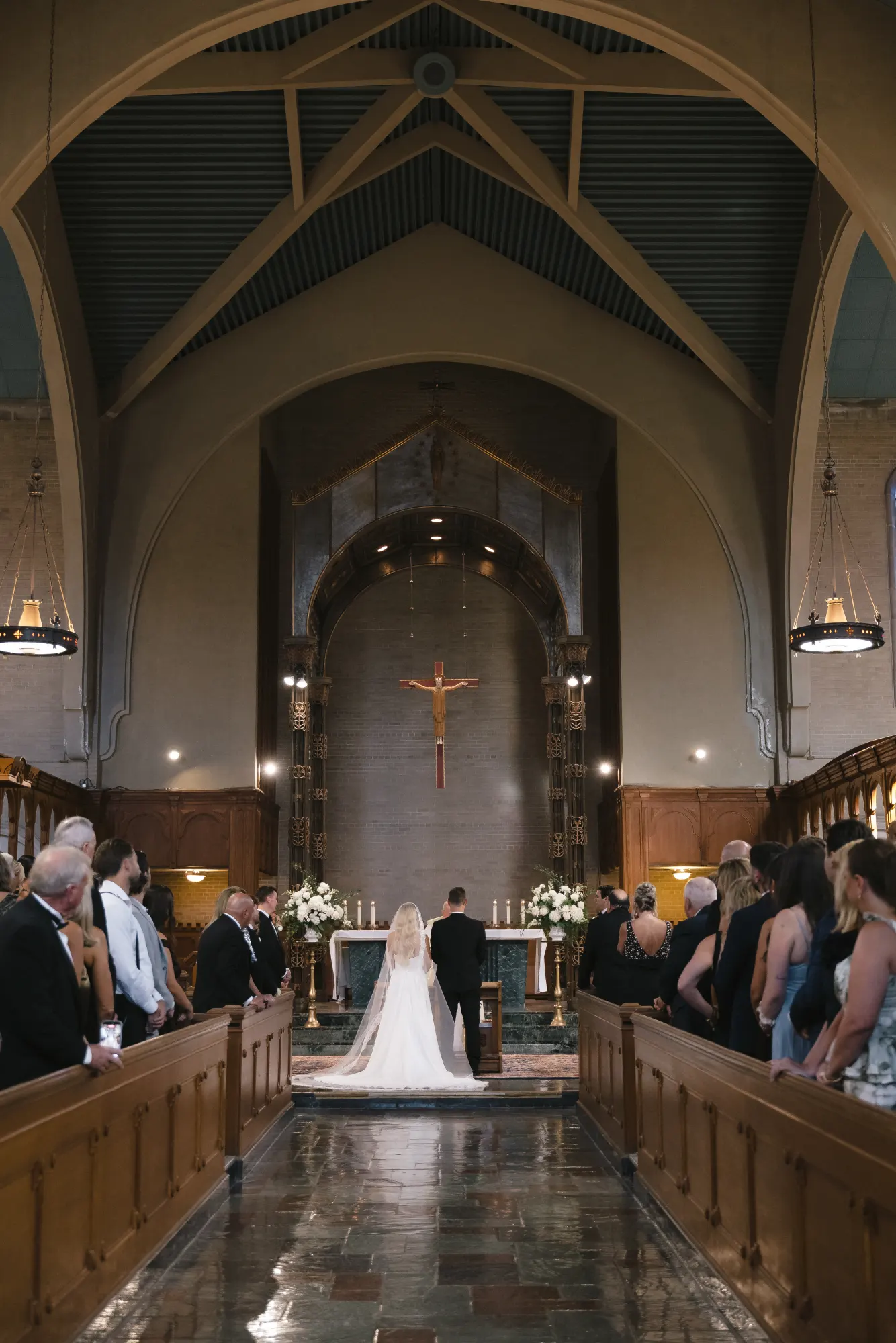 The wedding ceremony beneath the chapel's timbered arch ceiling