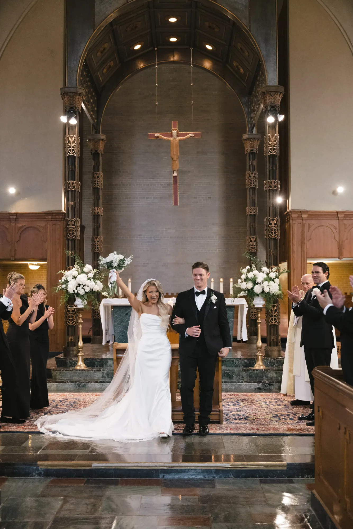 The newlyweds are presented as guests applaud