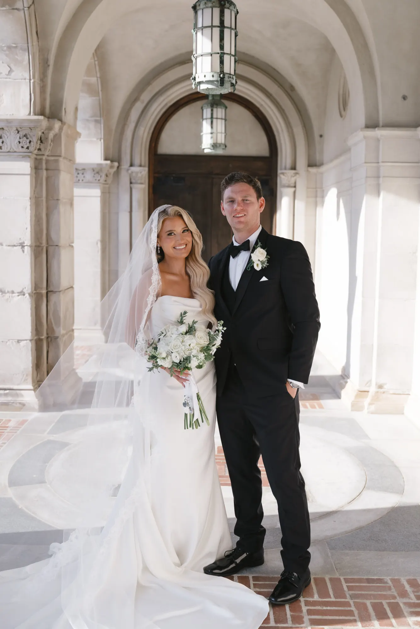 The newlyweds beneath the arched stone entry of the chapel