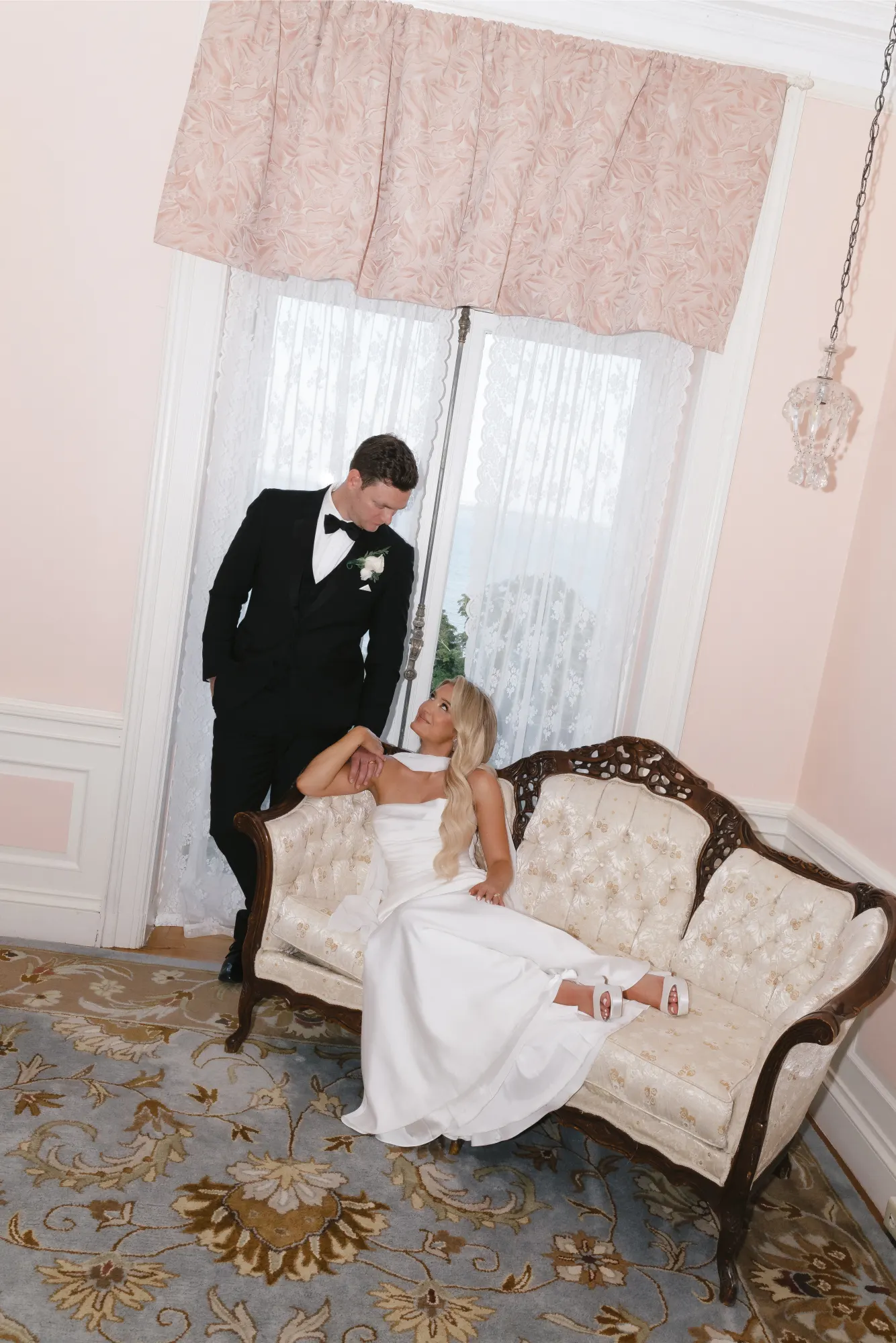 The newlyweds relax together on the antique settee