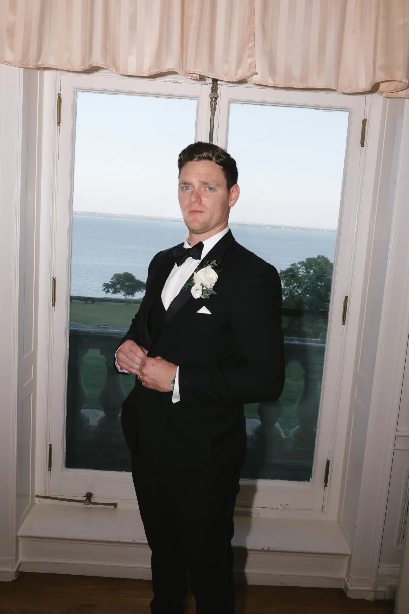 Groom portrait in the window light with the bay beyond