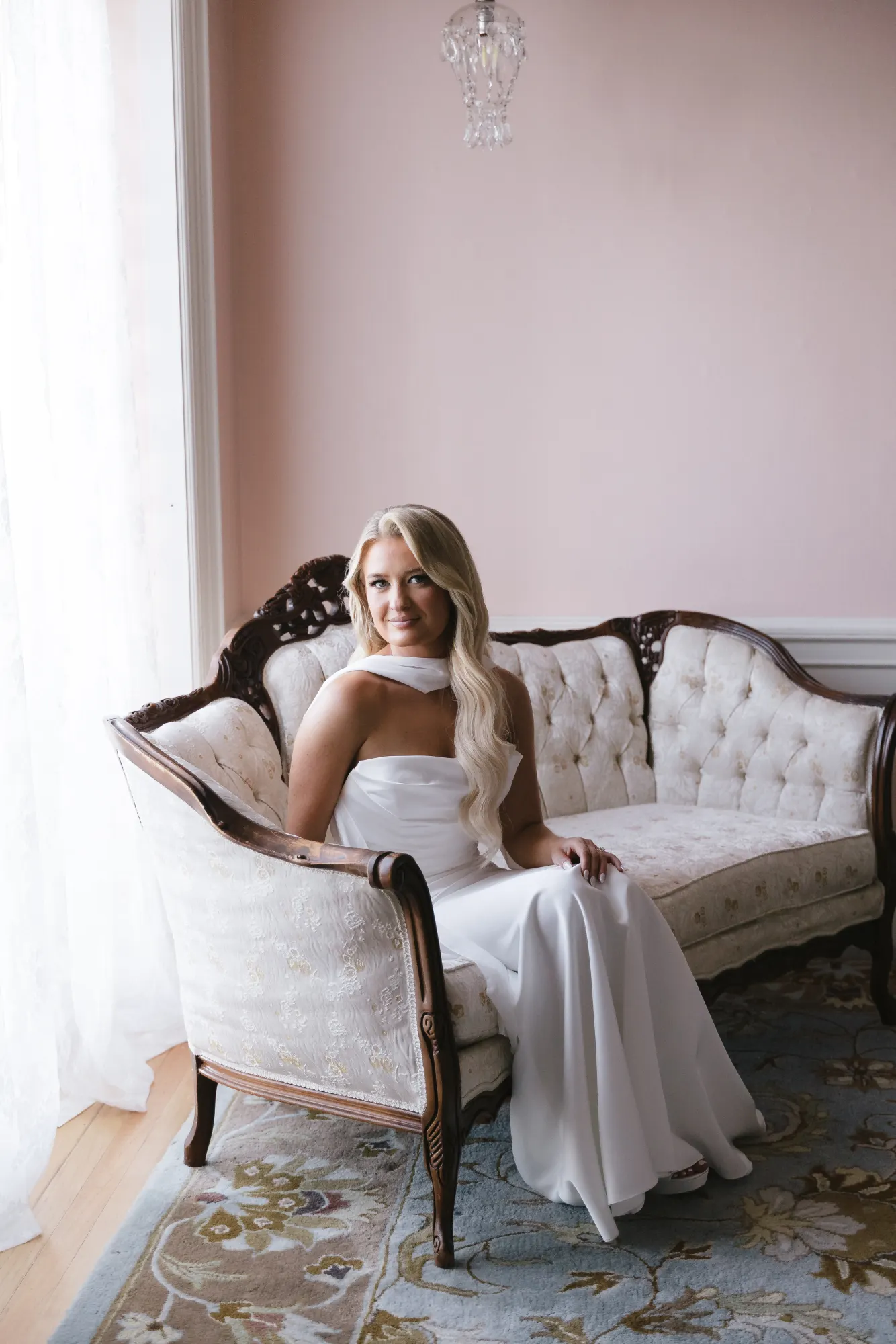 Bridal portrait on the tufted settee in the pink suite