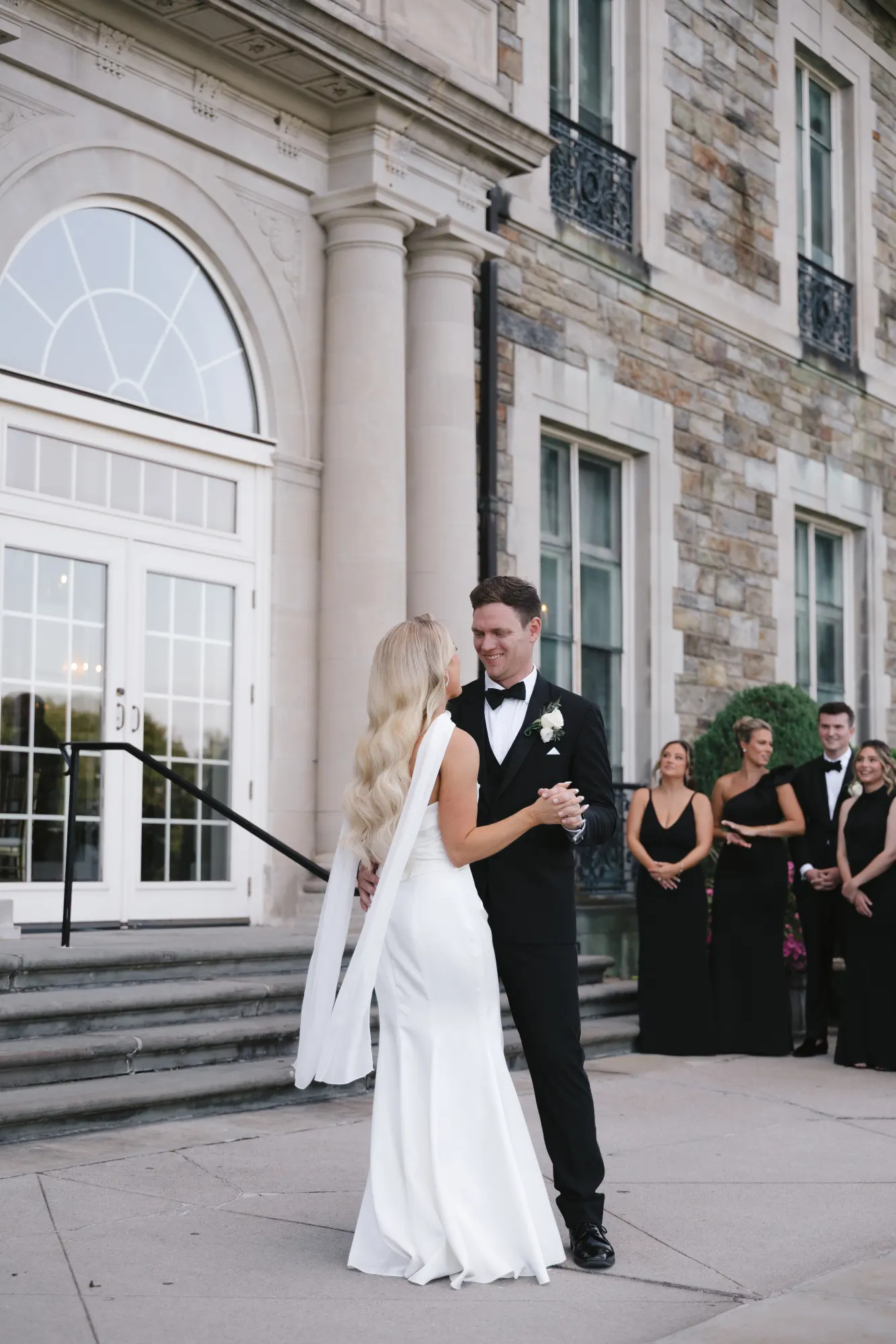 The first dance in front of the mansion's arched doors