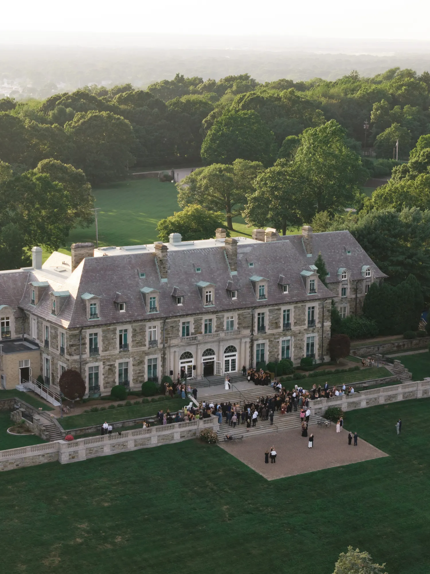 Aerial of Aldrich Mansion at golden hour with guests gathered on the back terrace