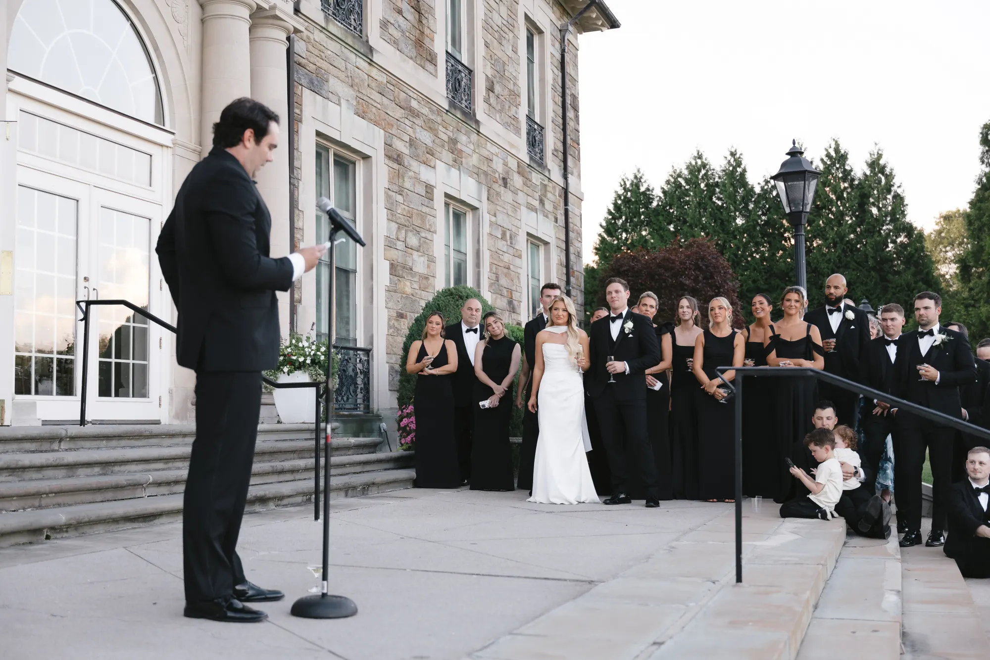 A toast with the whole wedding party lining the mansion steps