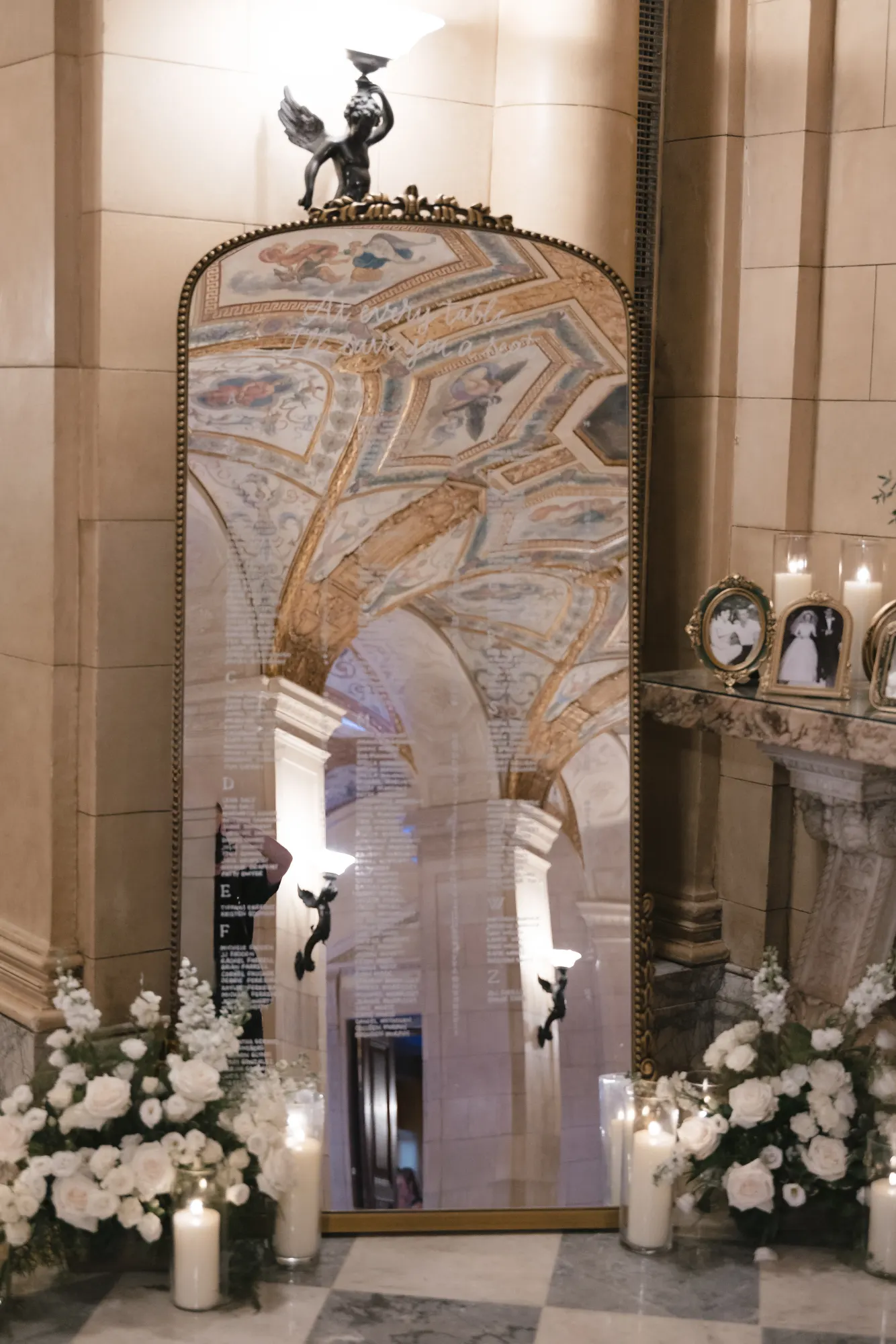 Candles and white florals beneath the gilded mosaic arch